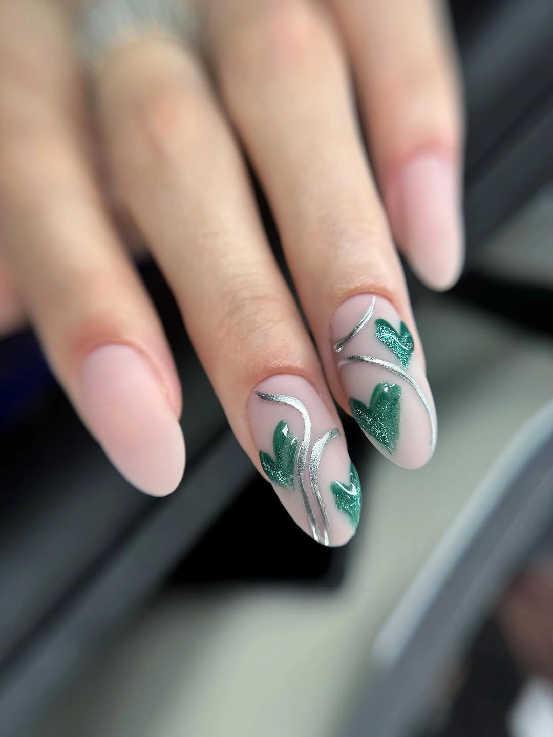 Blush almond nails with deep green leafy botanical accents