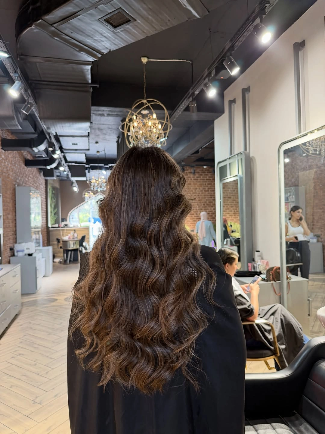 Long brown center-parted hair with repeated waves from the back
