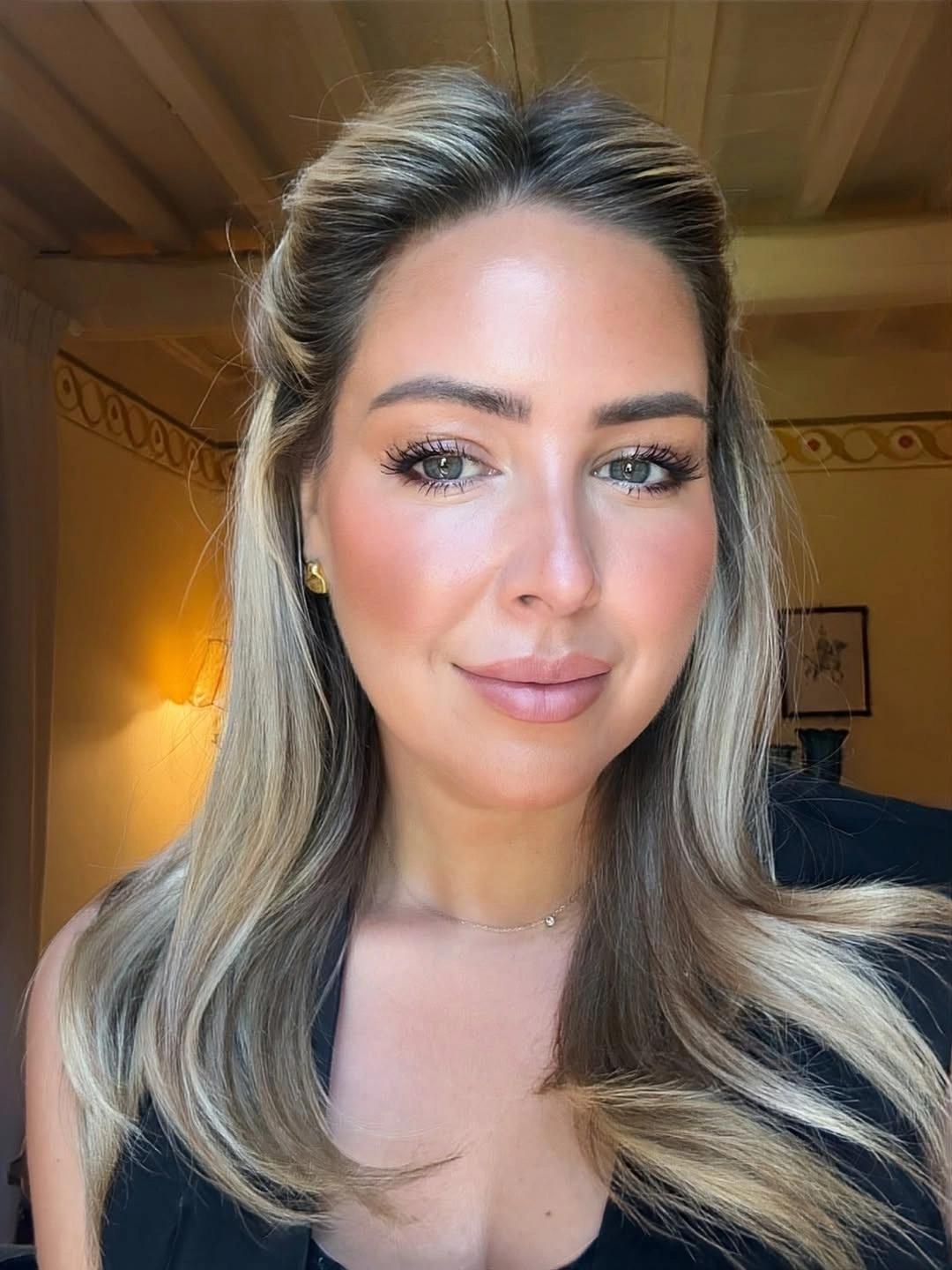 Ash blonde center-parted hair with loose waves and face-framing sides