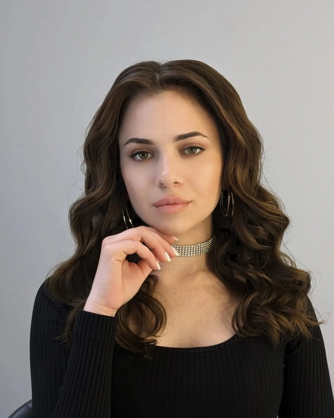 Medium-long brunette center-parted hair with open face-framing waves