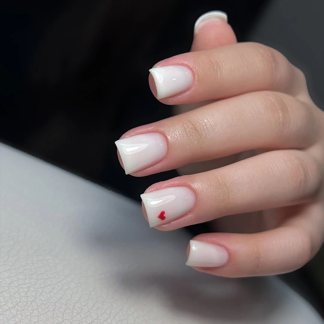 Short milky white squoval nails with one red heart
