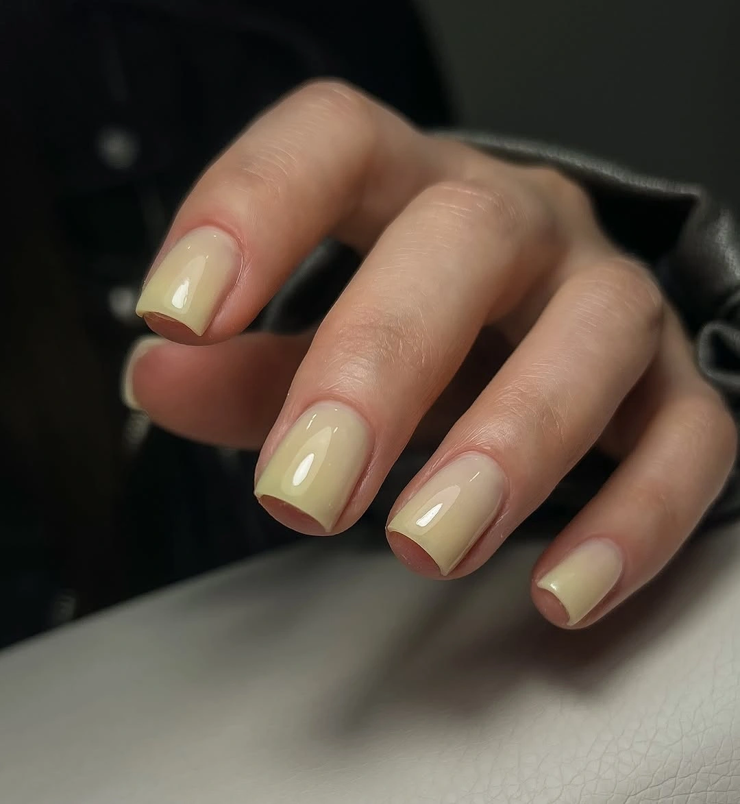 Short square nails in pale buttery yellow nude color