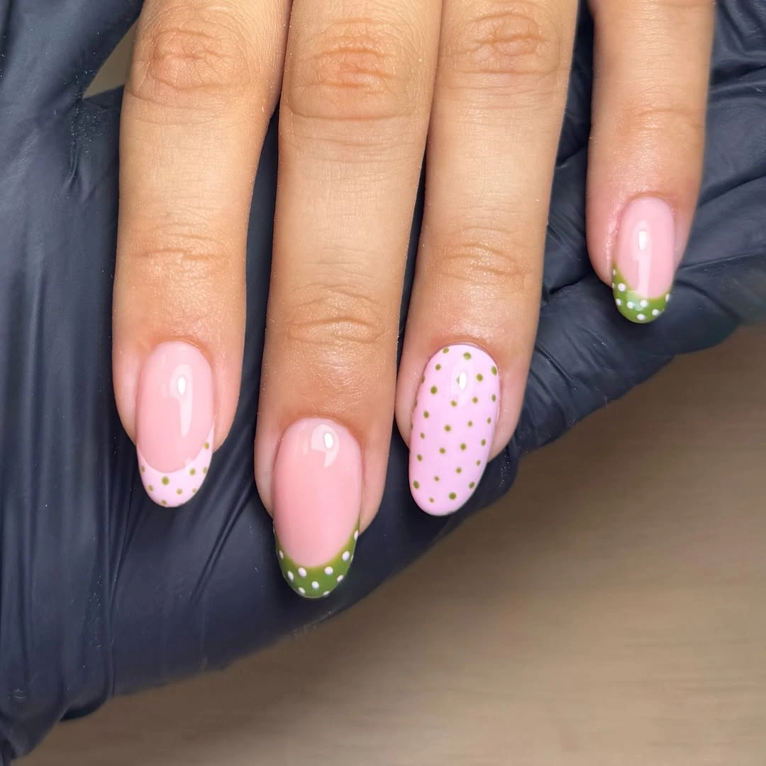 Pale pink almond nails with olive French tips and tiny yellow dot accent