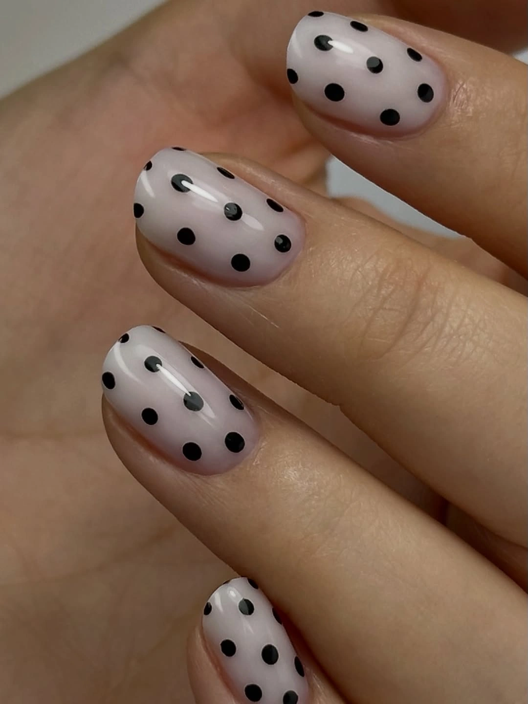 Short soft white oval nails with large spaced black polka dots