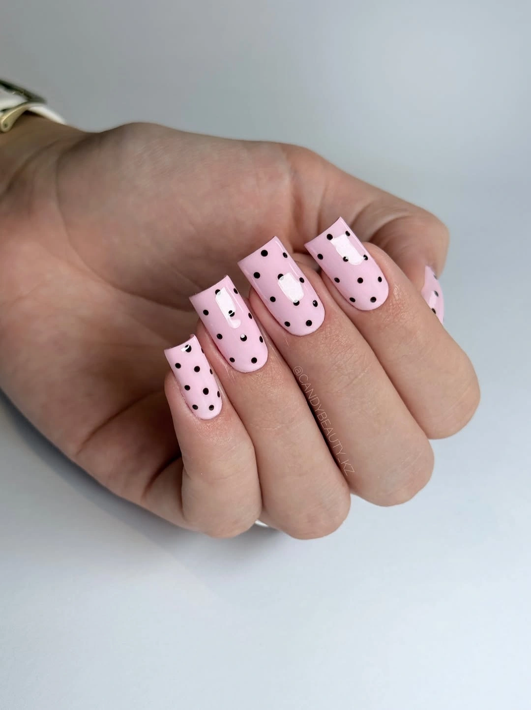 Long soft pink square nails with sharp small black polka dots