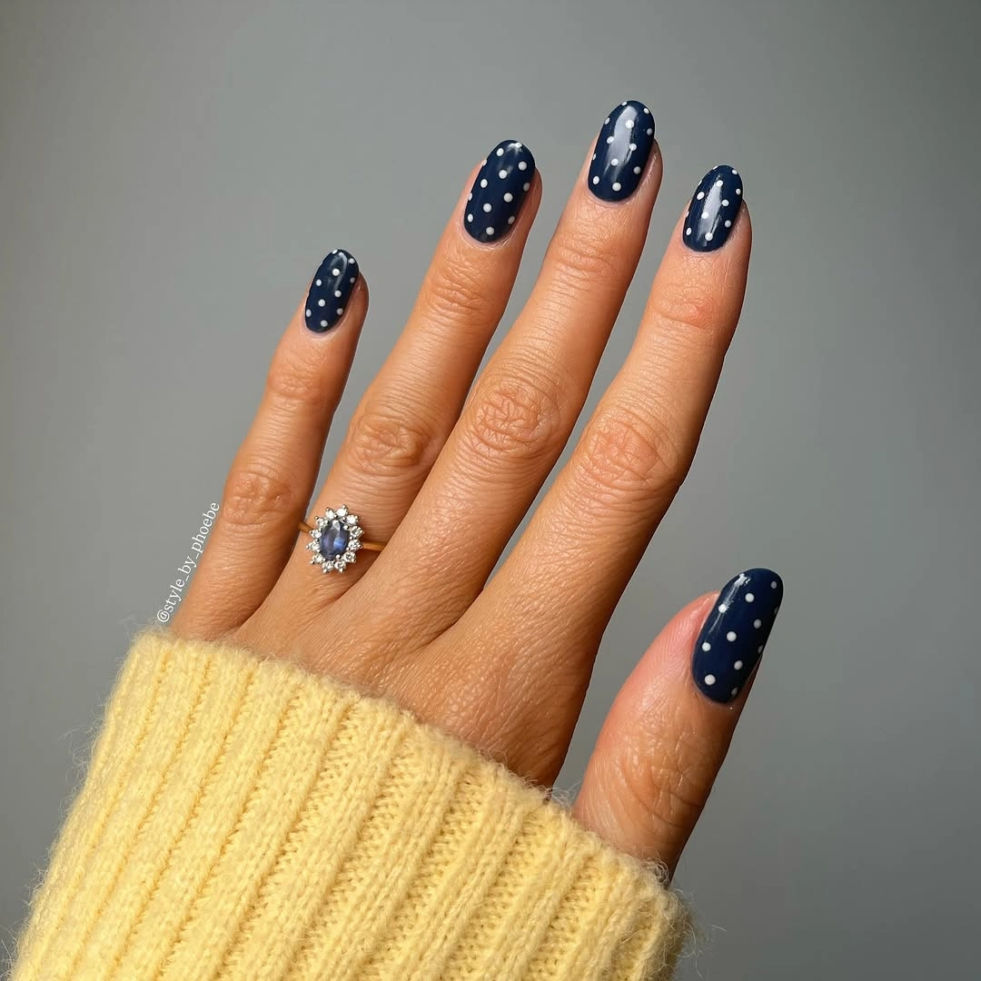 Short deep navy nails with small white polka dots