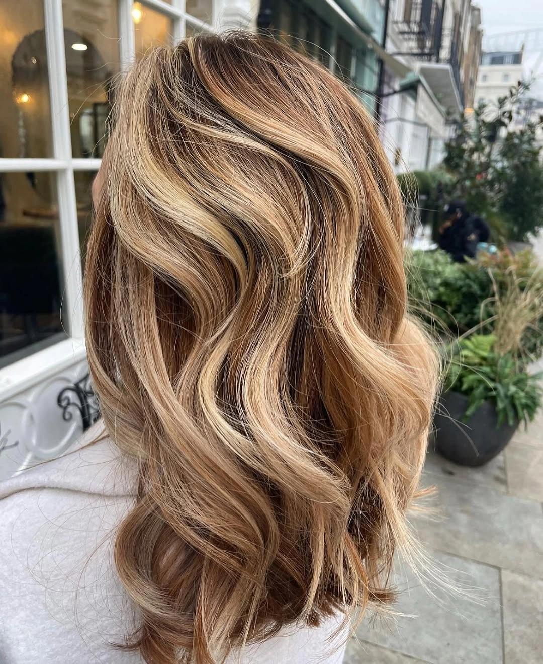 Warm blonde balayage waves with a darker root transition