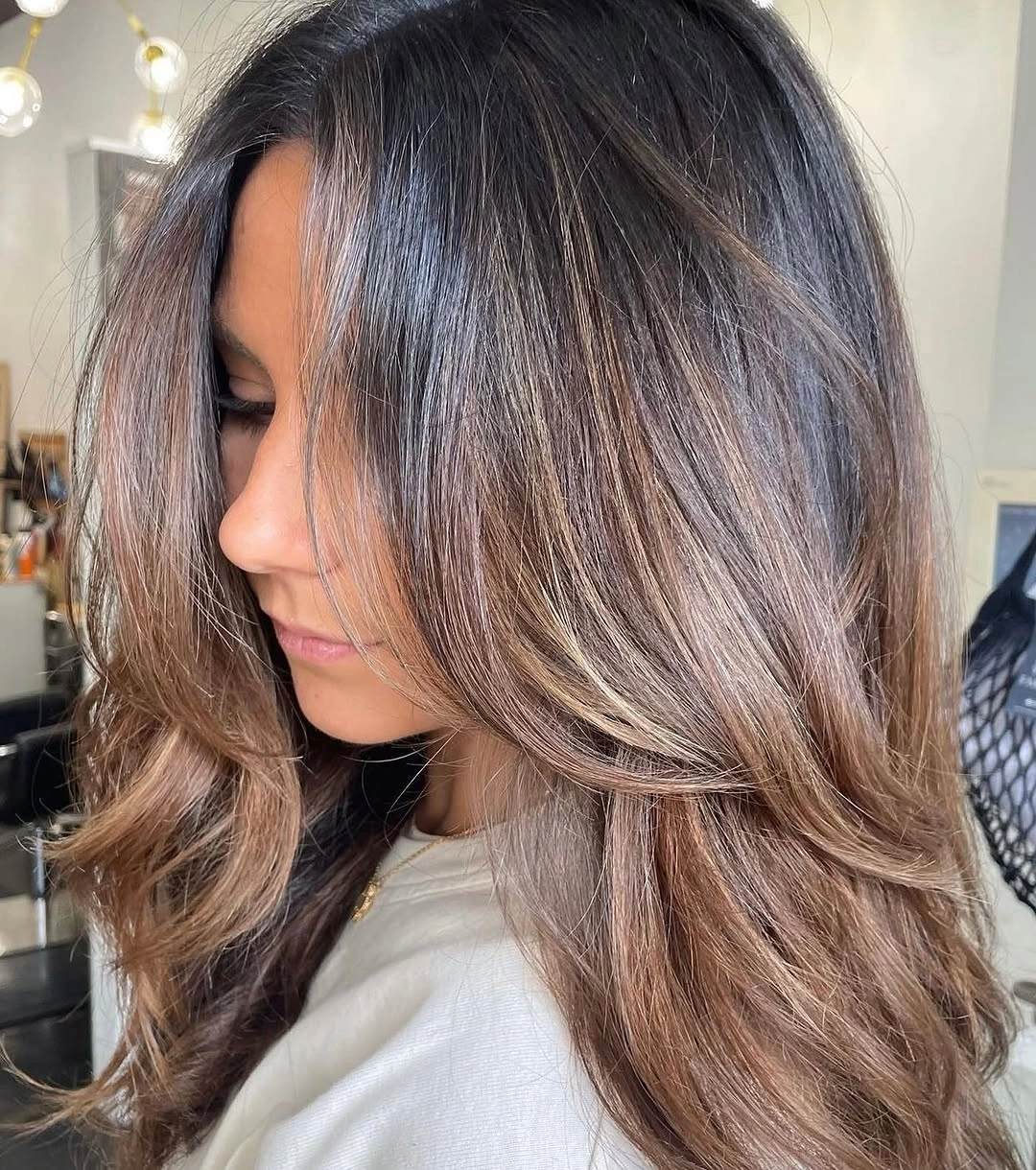 Medium brunette with cool beige face framing and feathered ends