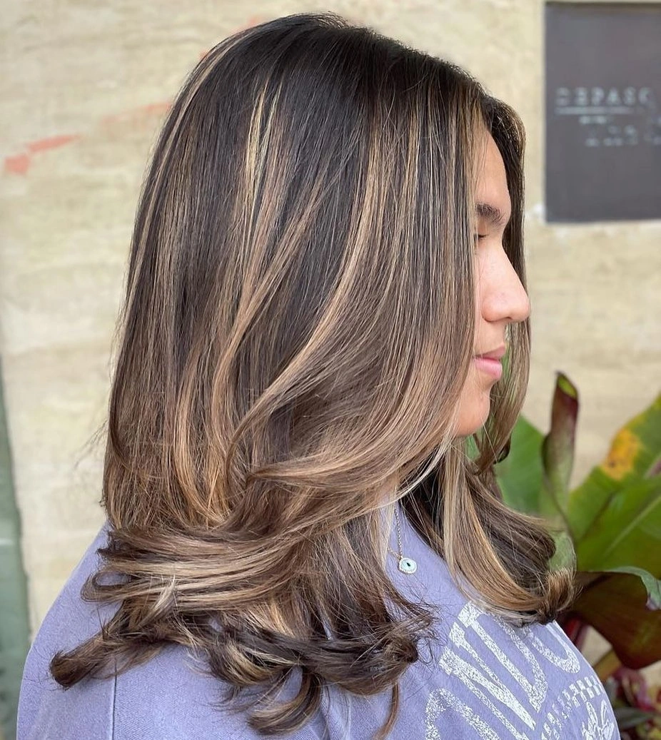 Medium brunette layers with warm beige ribbons and flipped ends