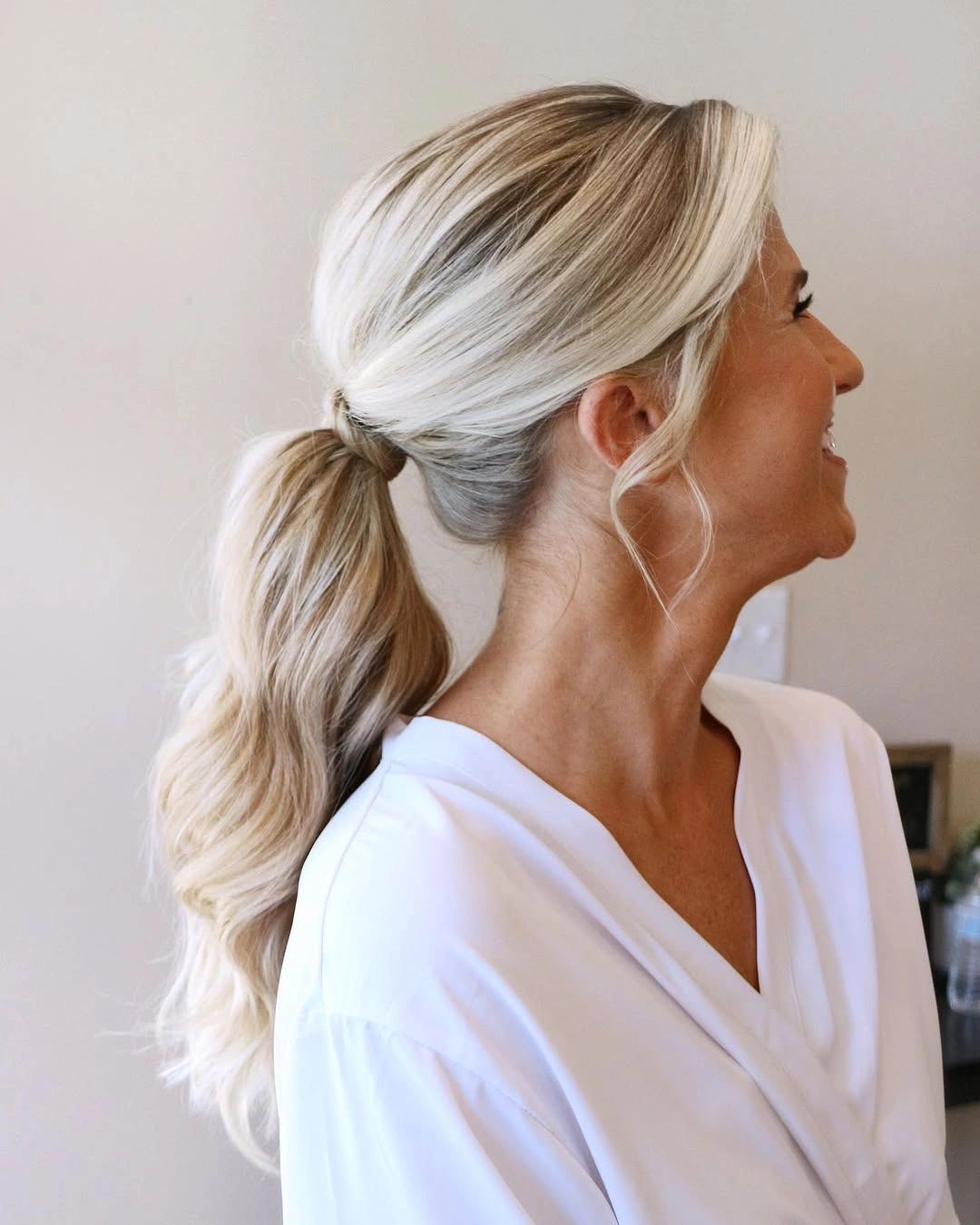 Pale blonde low ponytail with loose face framing strands
