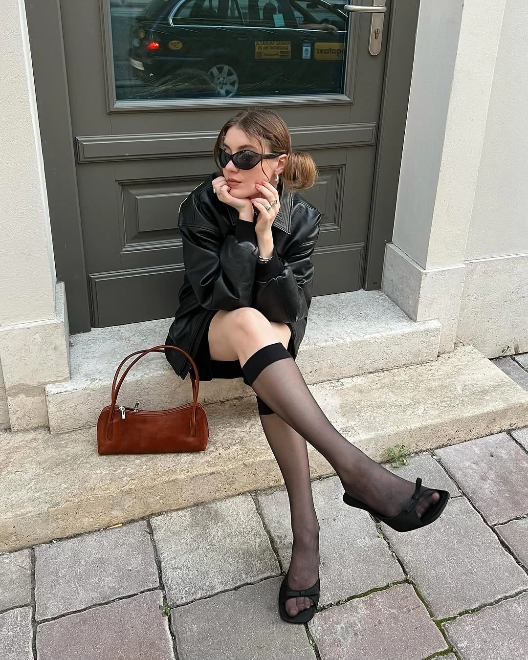 Black mini outfit with sheer socks heels and brown handbag