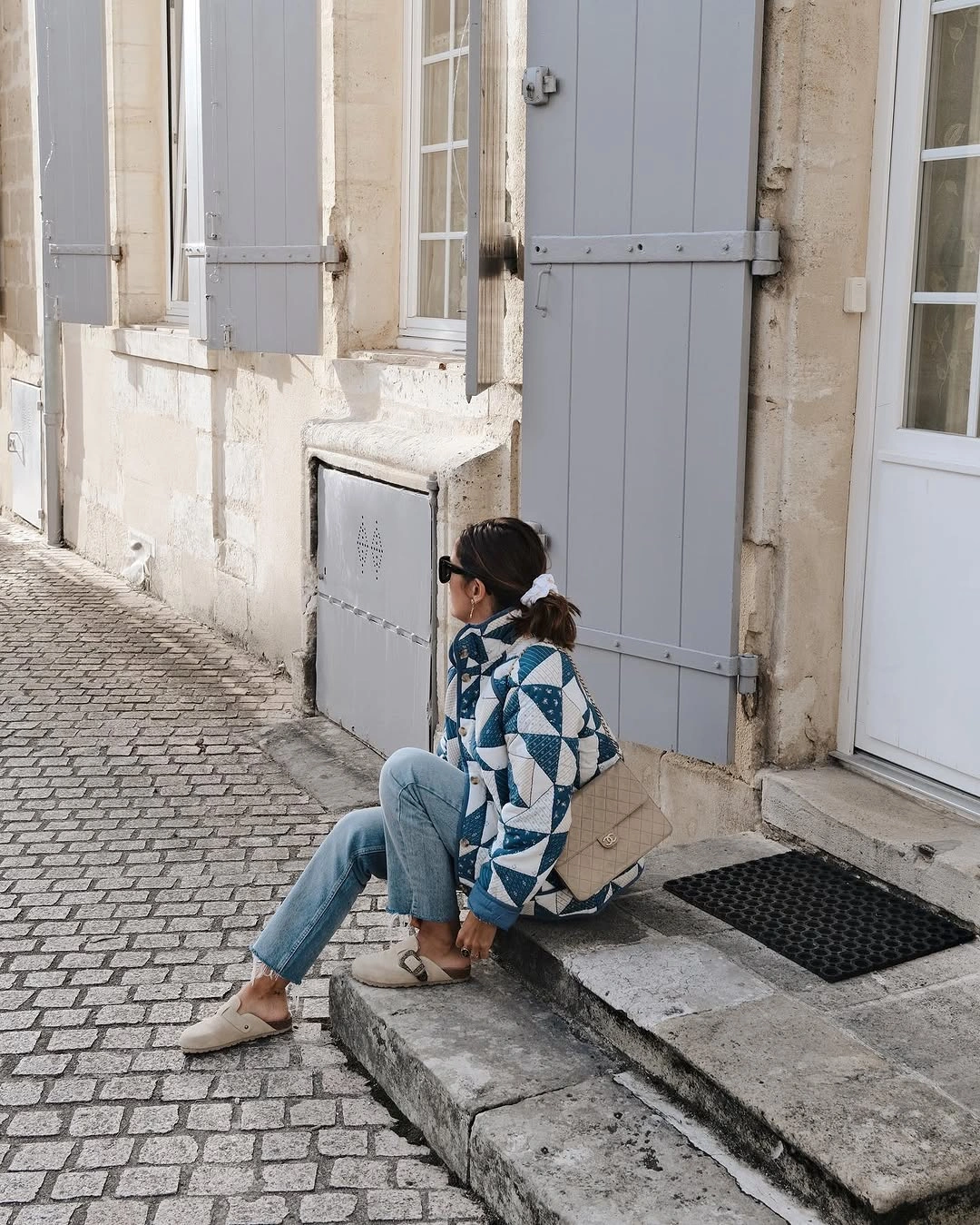 Blue geometric cardigan with pale jeans and beige accessories