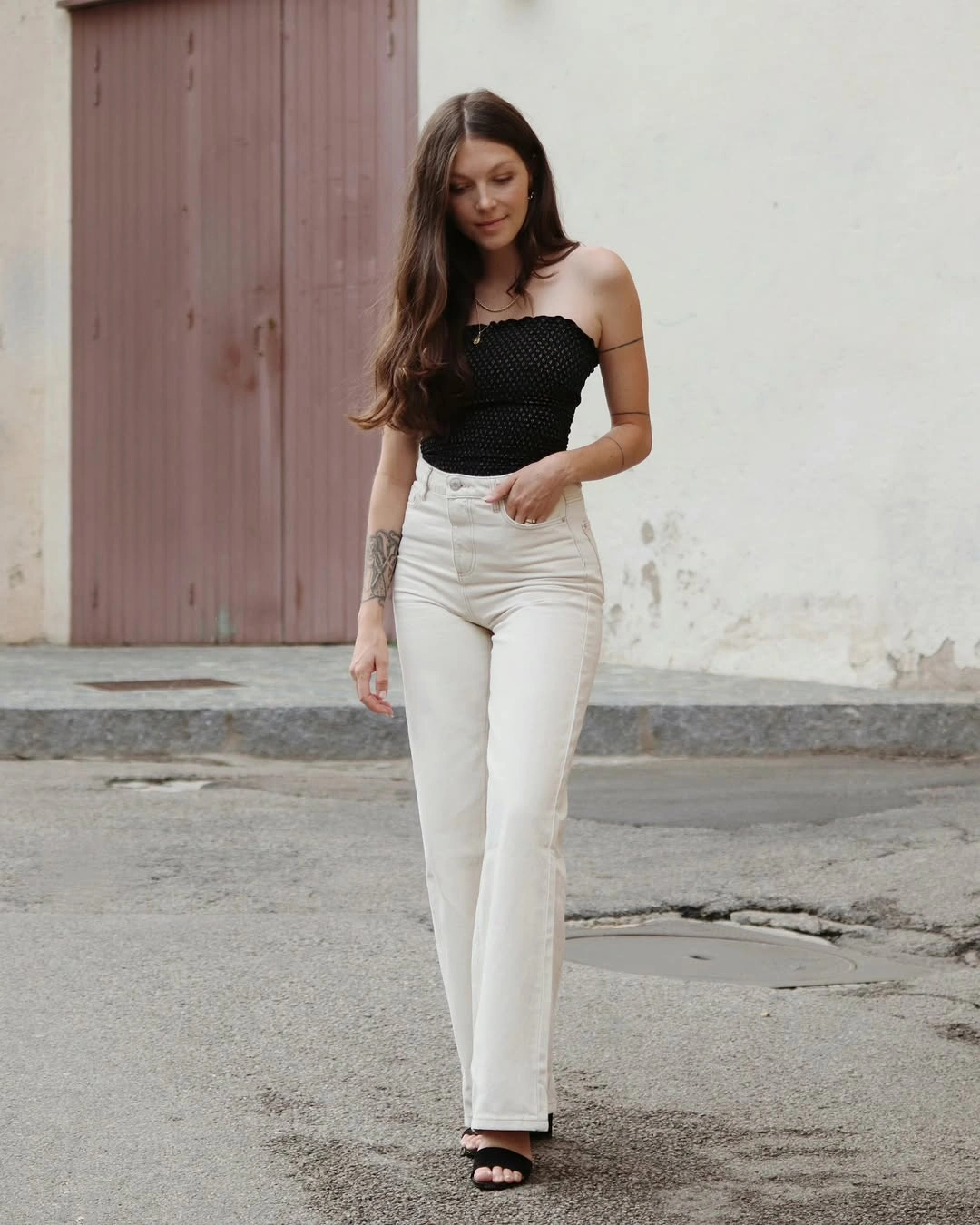 Textured black strapless top with high-waisted cream jeans