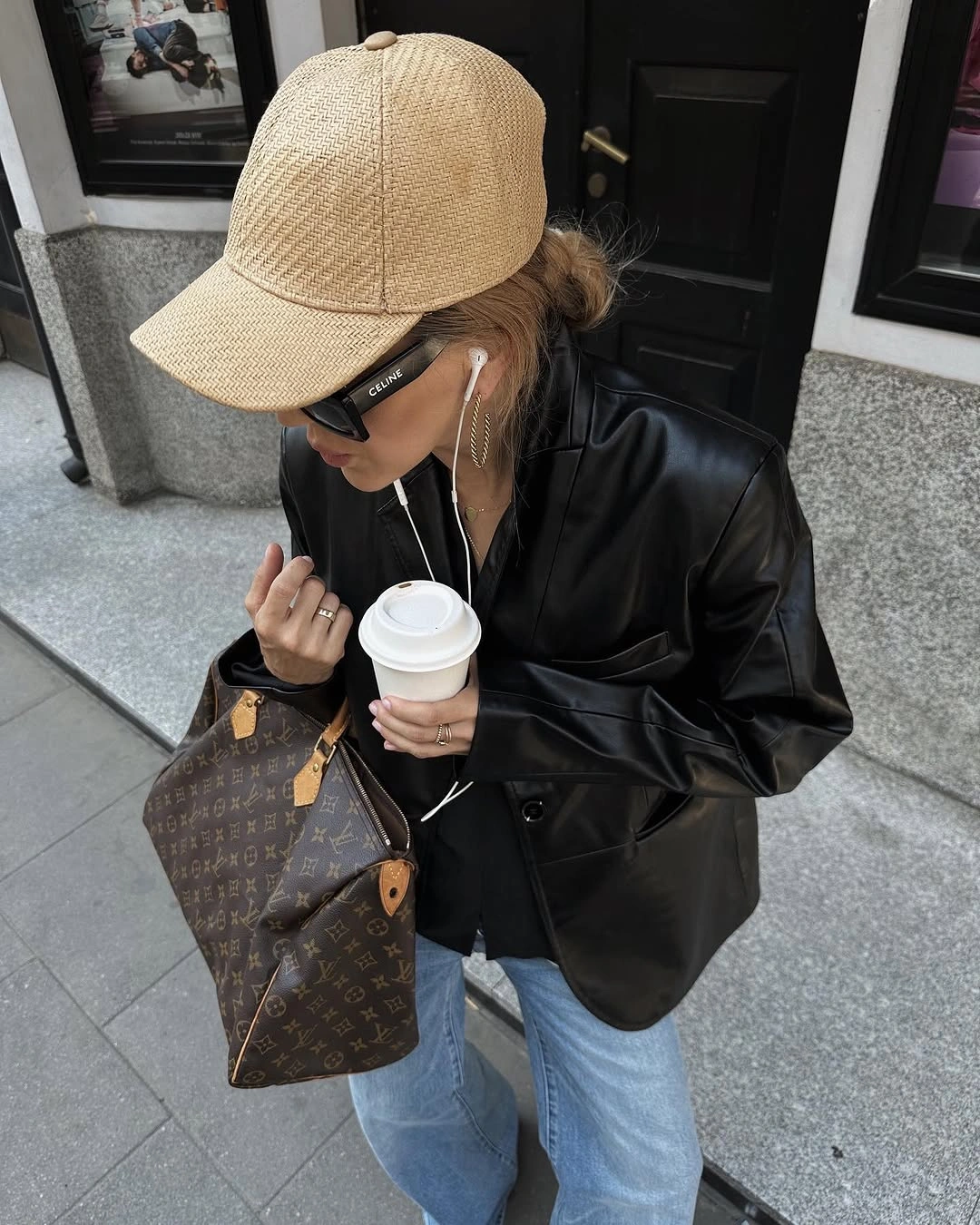 Black jacket with beige cap pale jeans and brown tote
