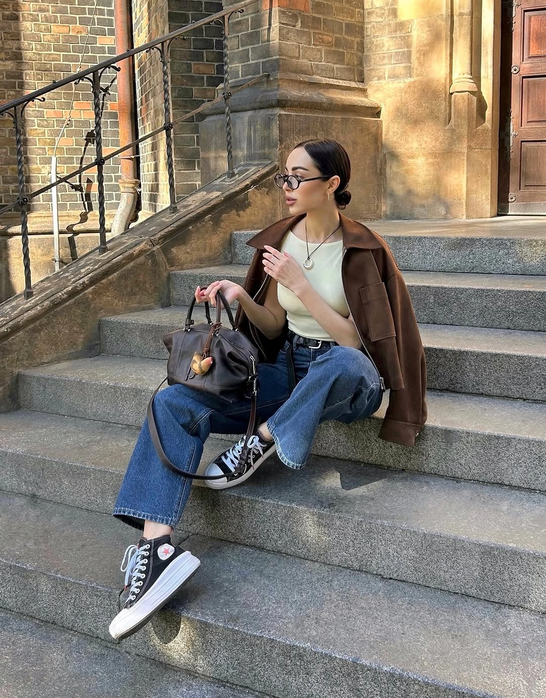 Brown jacket with pale green top blue jeans and high-top sneakers