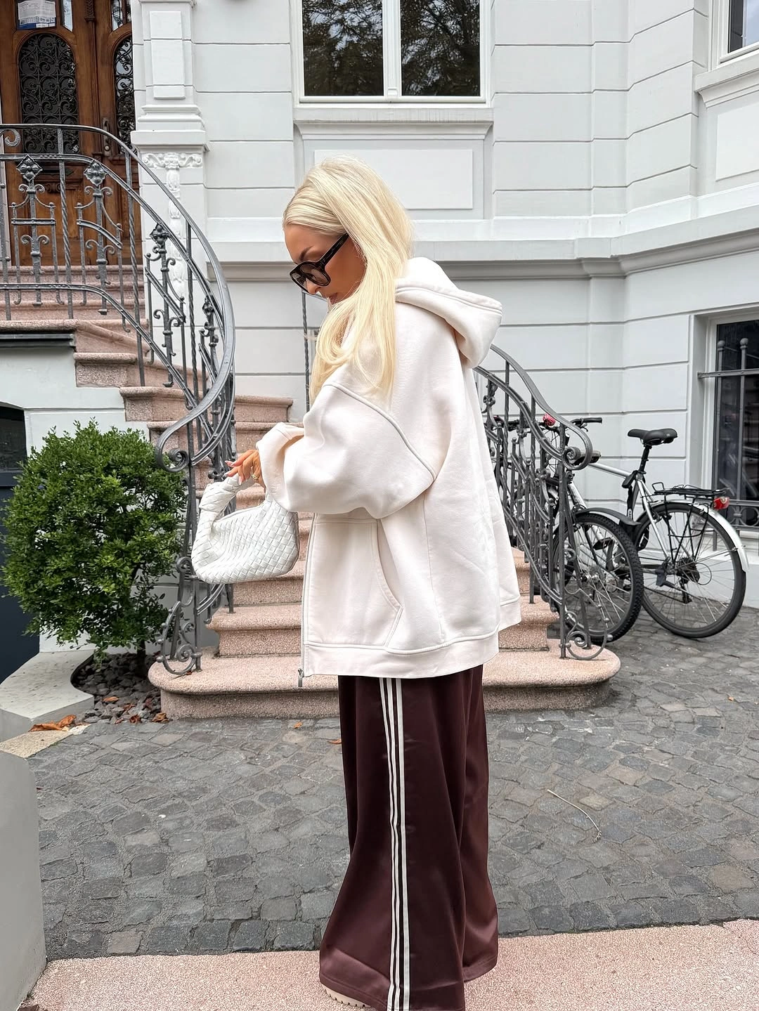 Ivory oversized hoodie with chocolate wide trousers and white bag