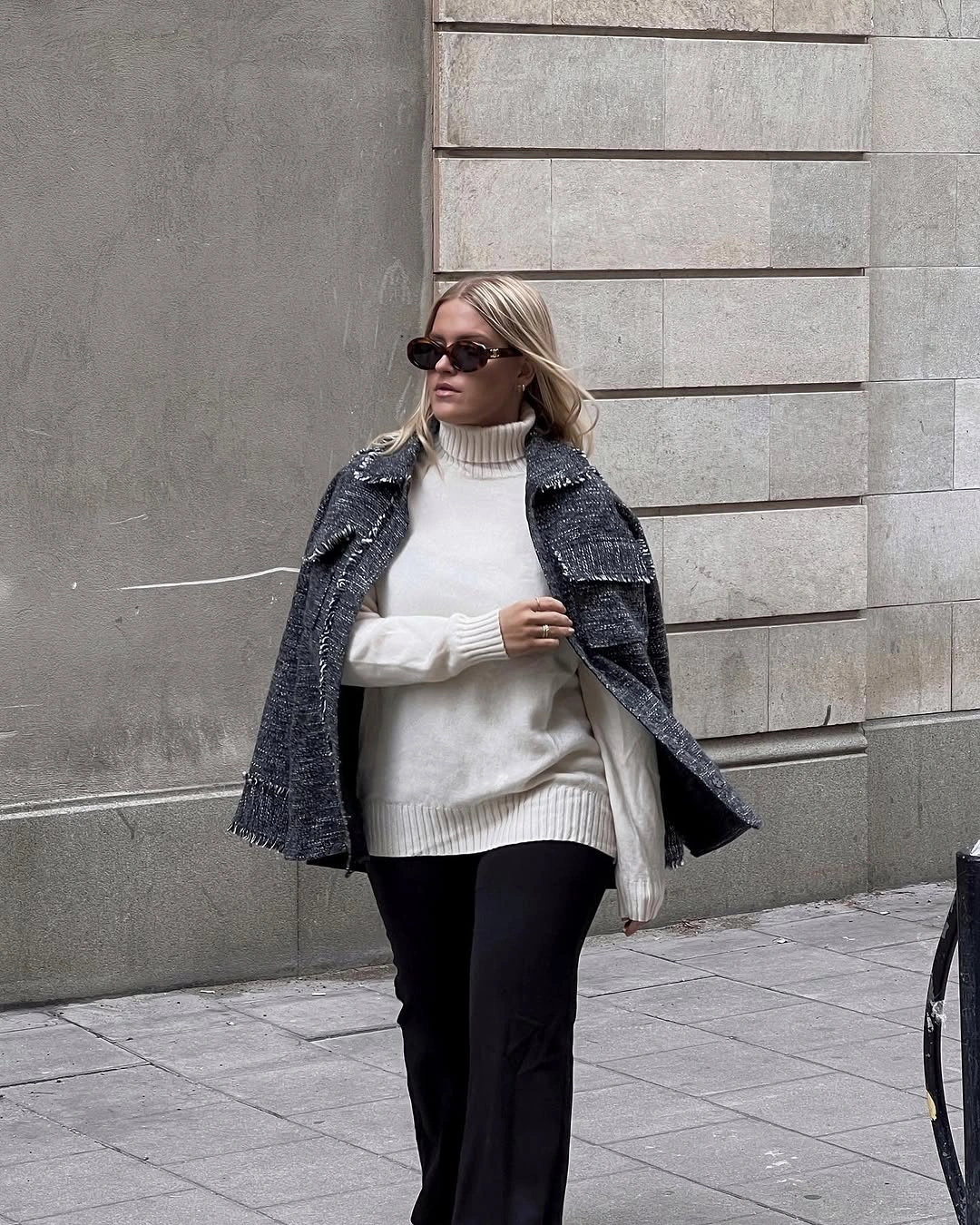 Ivory turtleneck with black trousers and draped textured jacket