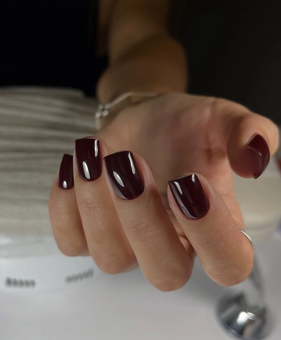 Dark burgundy short square nails with glossy highlights