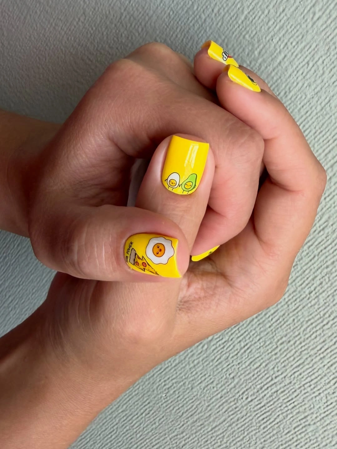 Yellow square nails with small playful outlined drawings