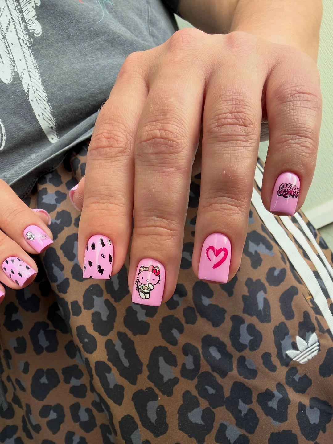 Pink short square nails with spots and playful heart detail