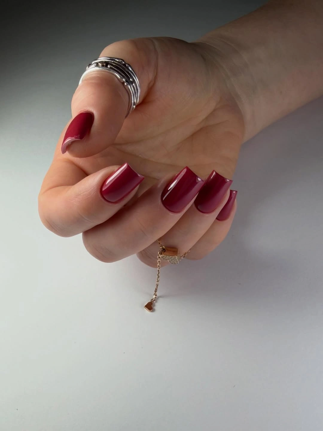 Glossy deep wine red short nails with rings