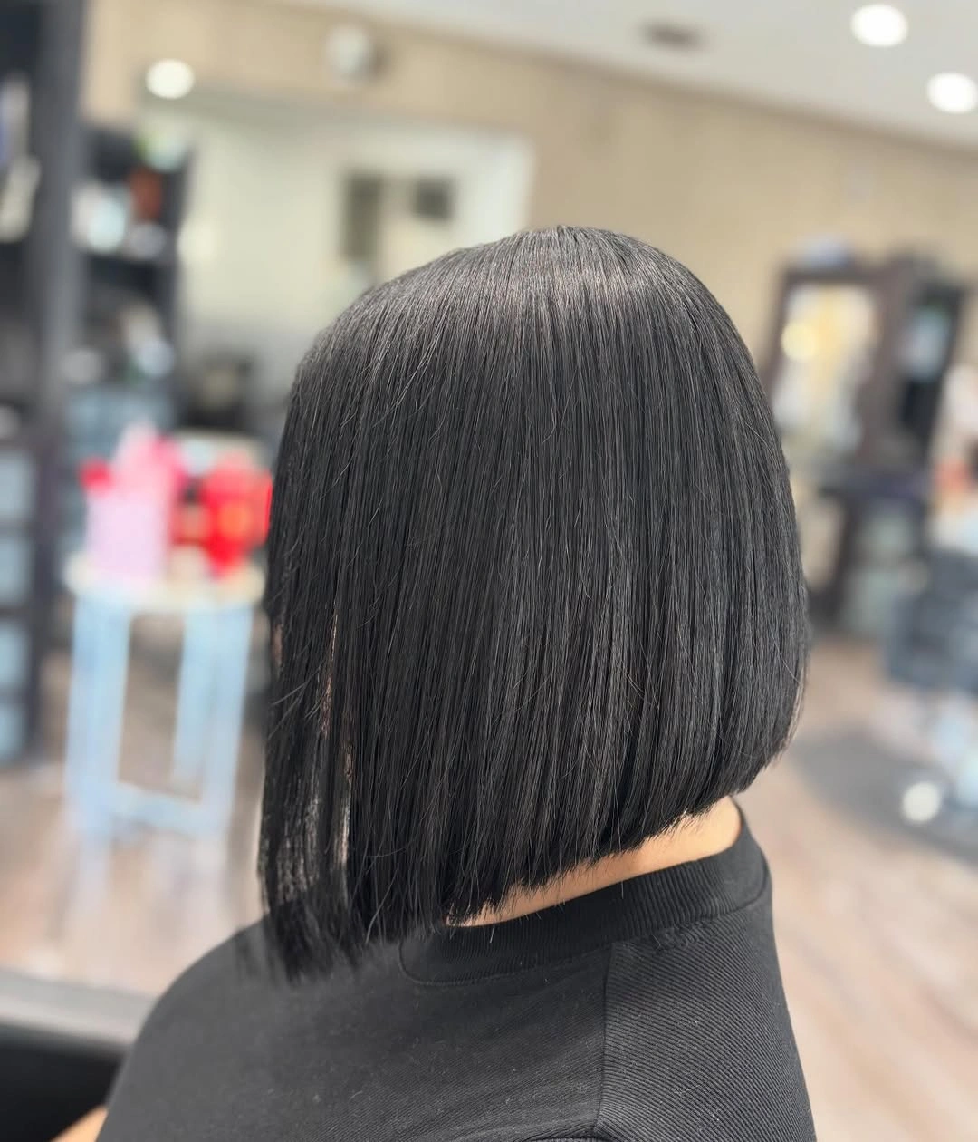 Dark straight bob with rounded crown and blunt nape edge