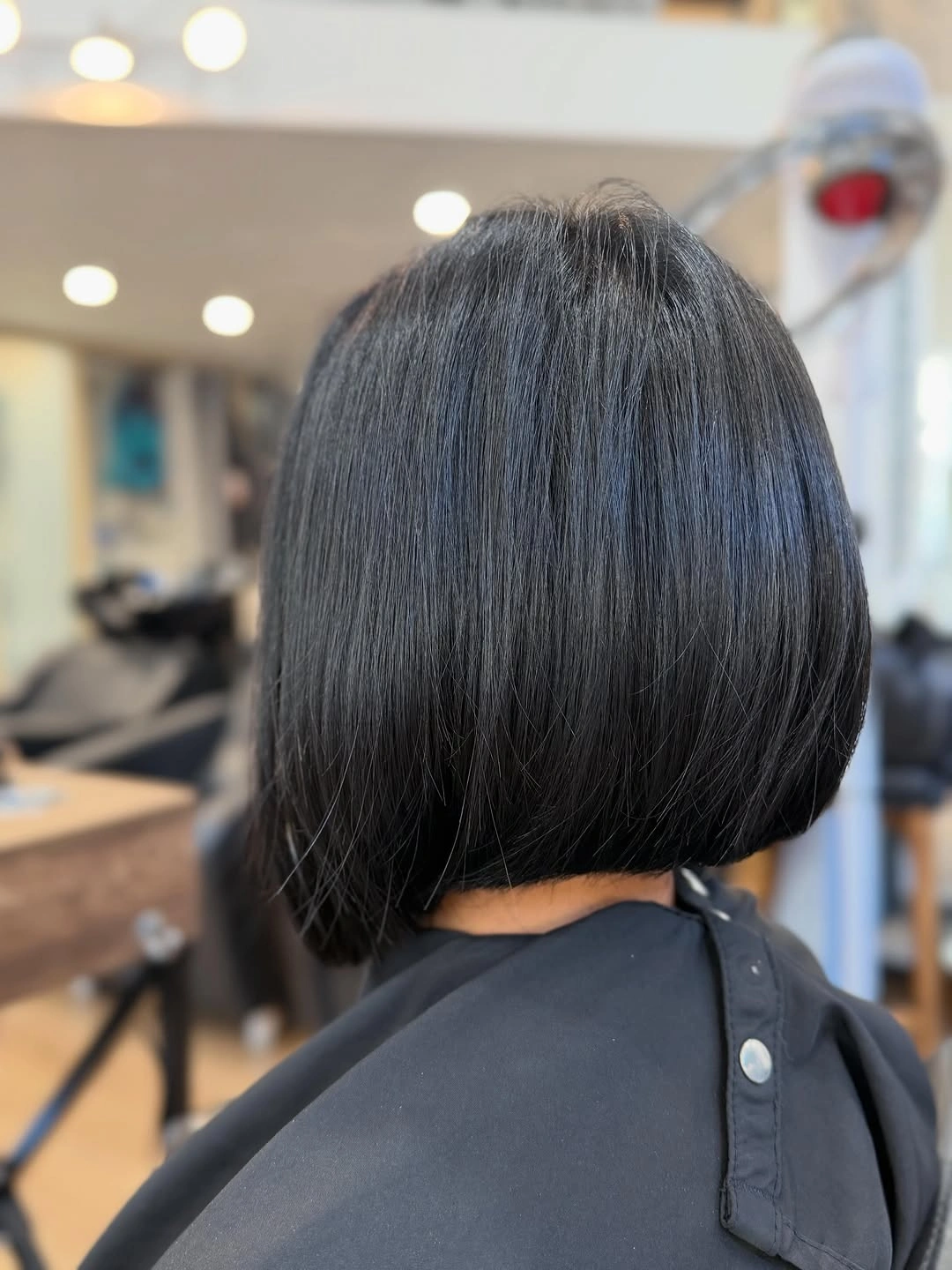 Glossy dark short bob with rounded back and compact nape