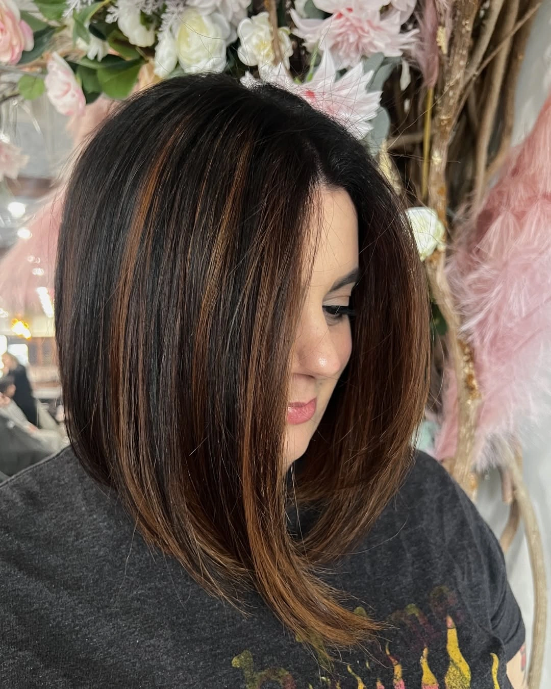Brunette angled bob with warm caramel ribbons near the face
