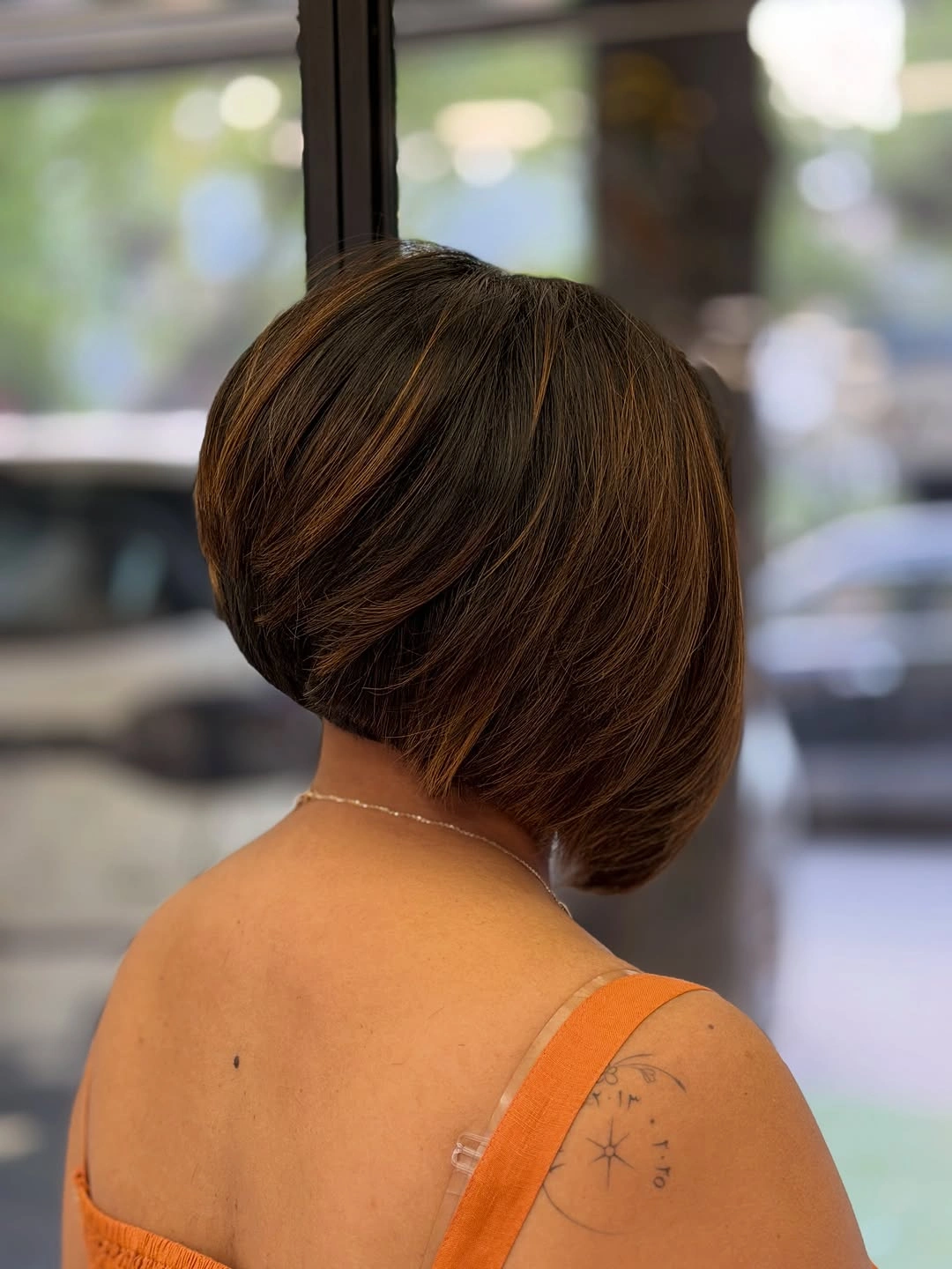 Short stacked dark bob with warm brown ribbons