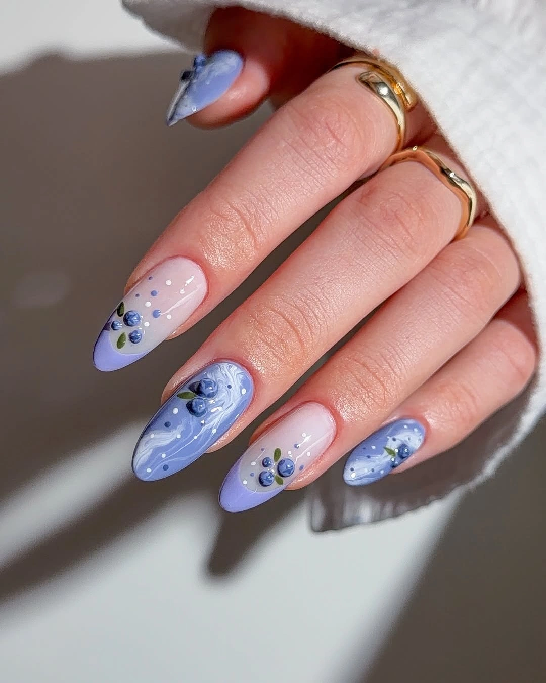 Blue almond nails with dots and raised-looking floral details