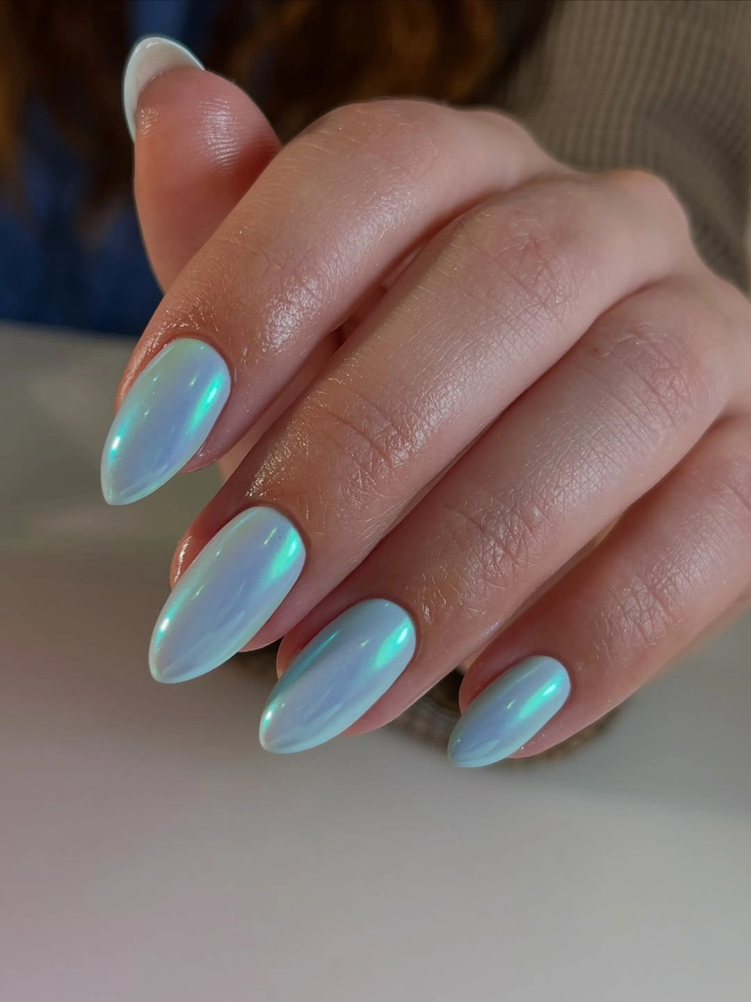 Icy aqua-blue almond nails with uniform iridescent-looking finish