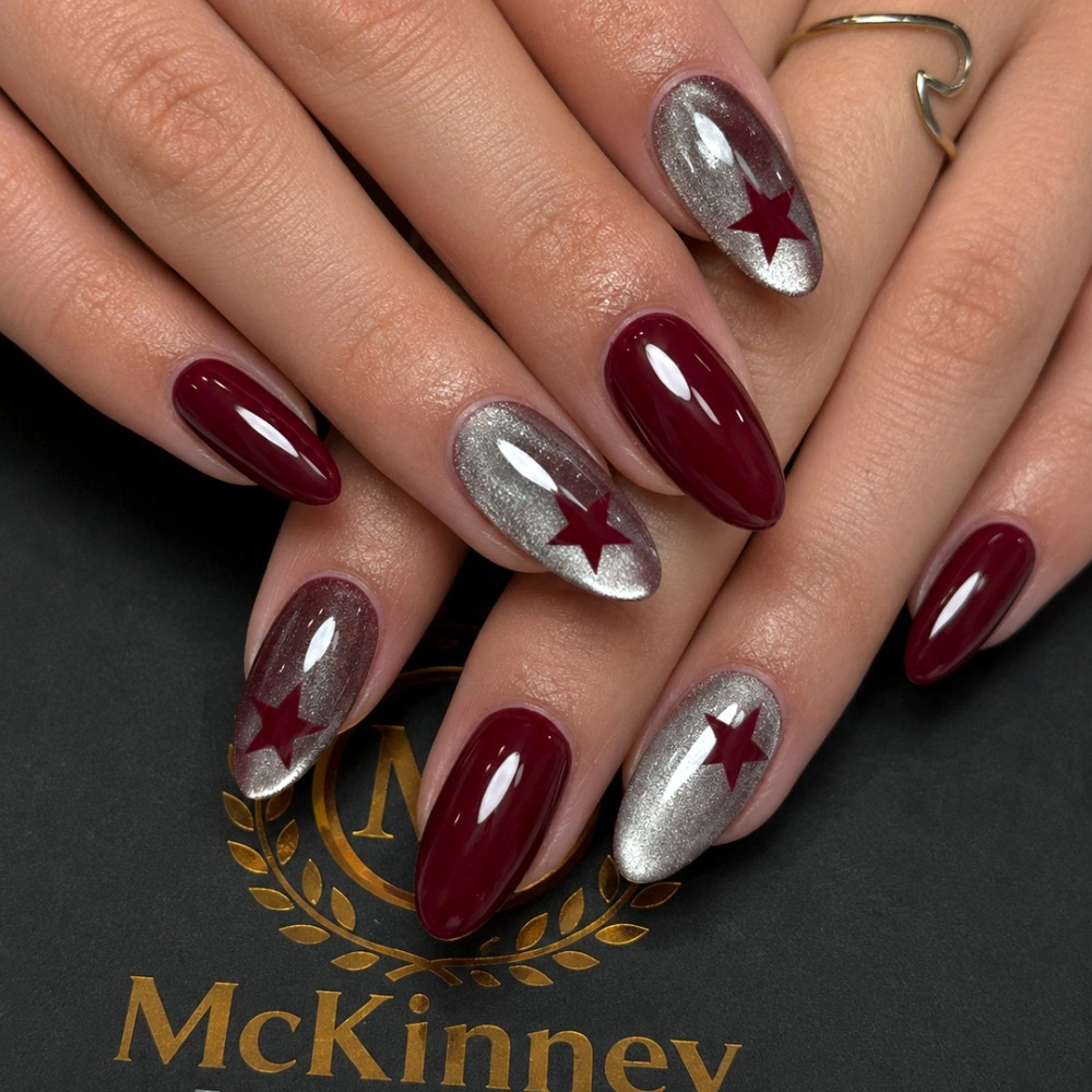Burgundy and silver almond nails with star-like shapes