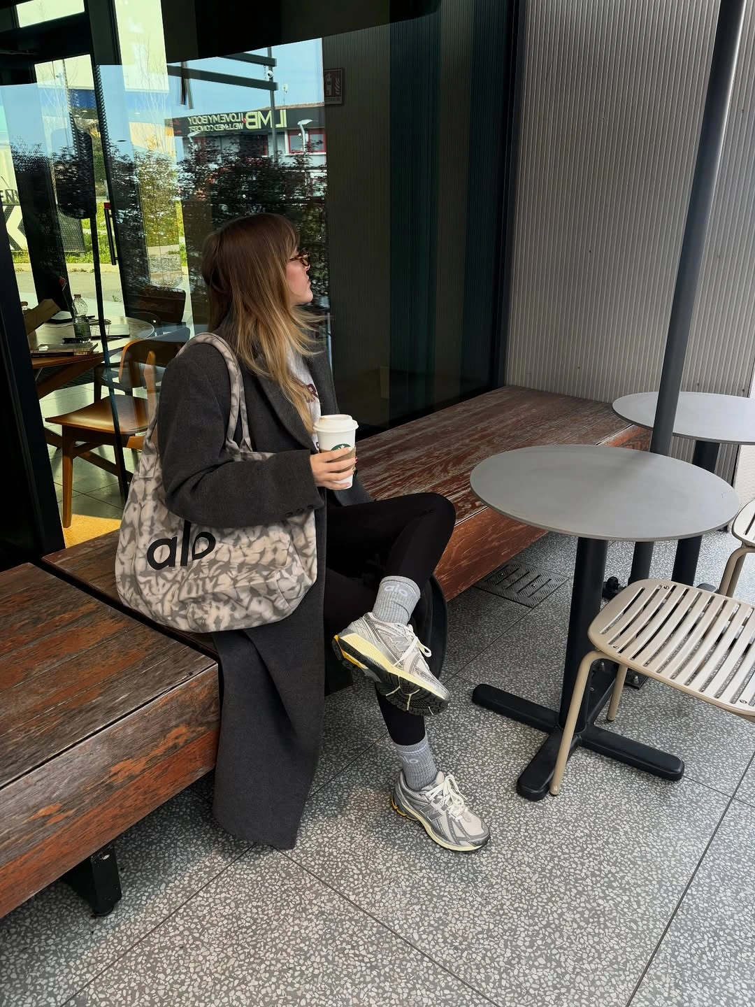 Dark blazer black trousers light sweatshirt trainers and tote