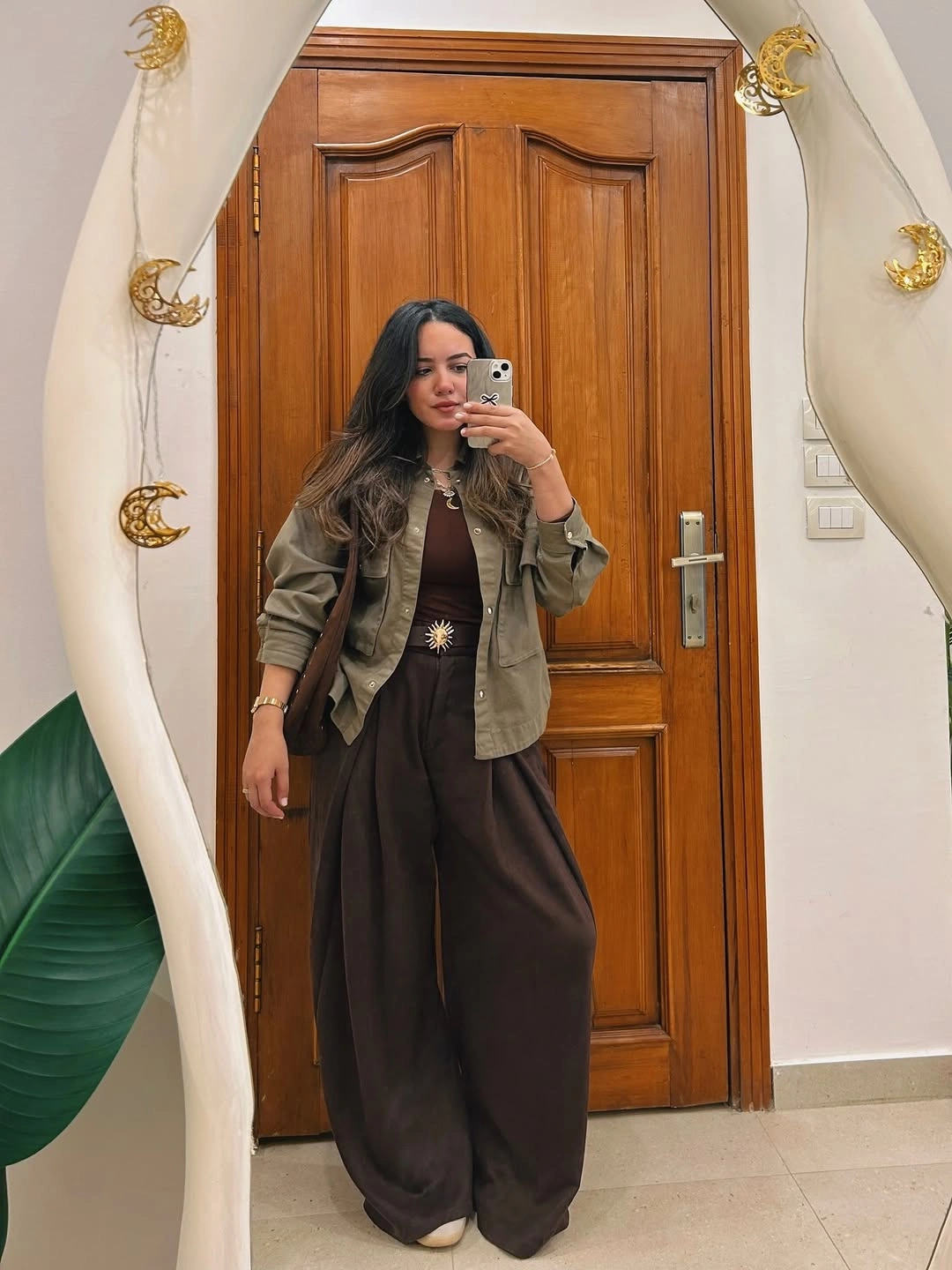 Olive utility jacket brown top and wide dark trousers