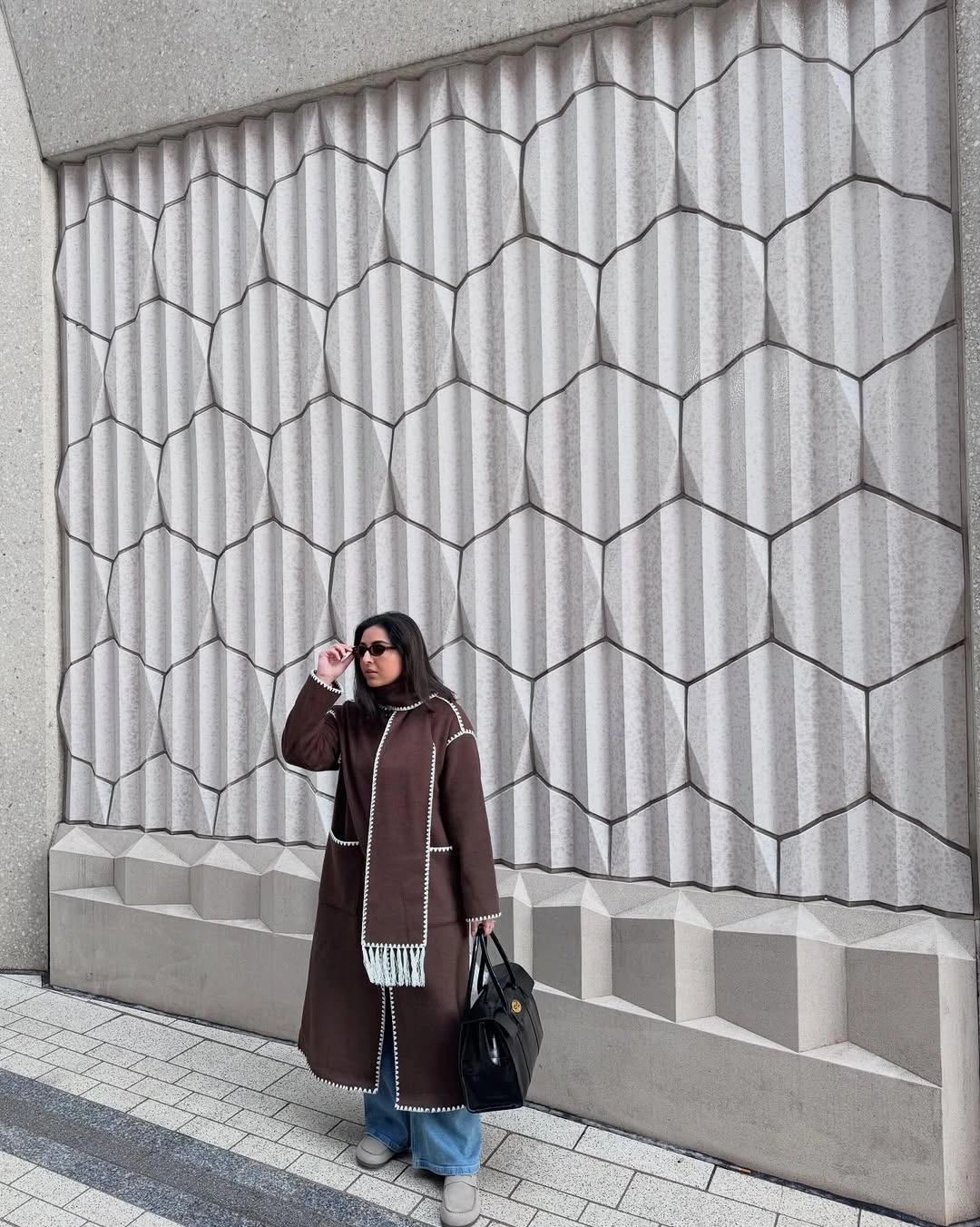 Long dark brown coat with scarf and flared blue jeans