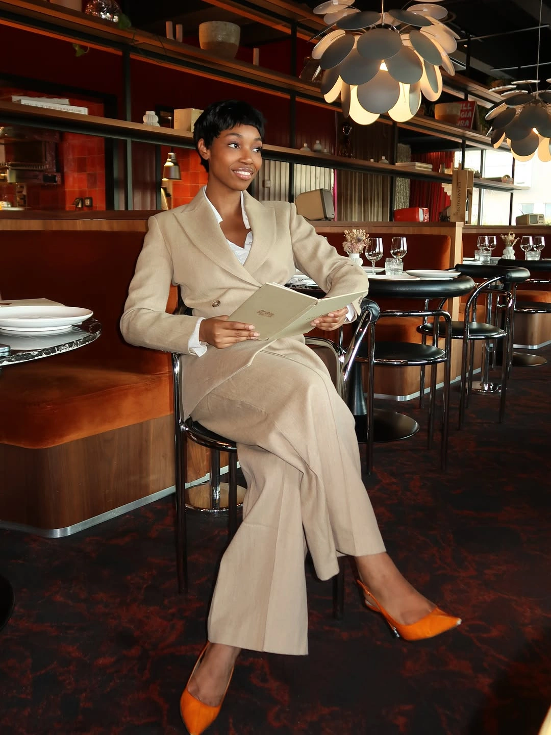 Cream tailored suit with light top and orange pointed shoes