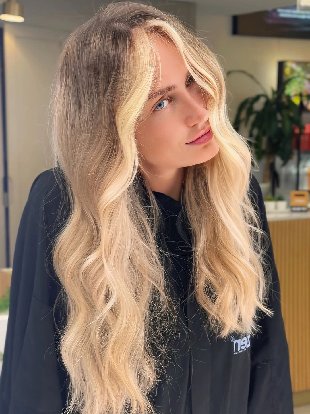 Long blonde waves with dark roots and bright face-framing pieces
