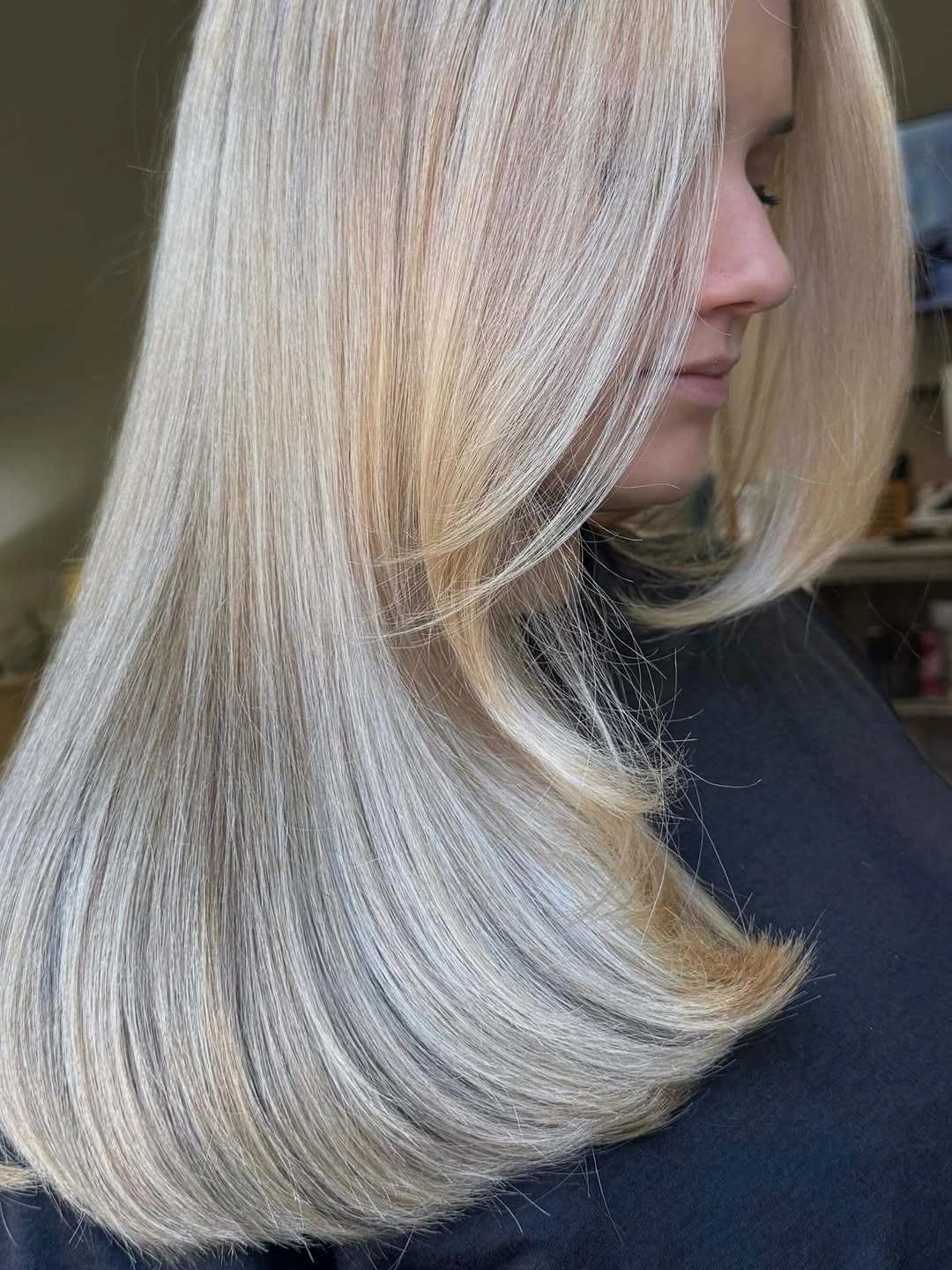 Side profile of long straight pale blonde hair with turned ends
