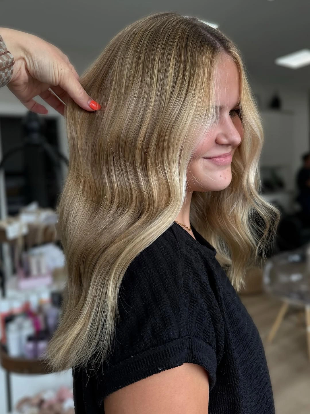 Side view of wavy beige blonde hair with darker roots