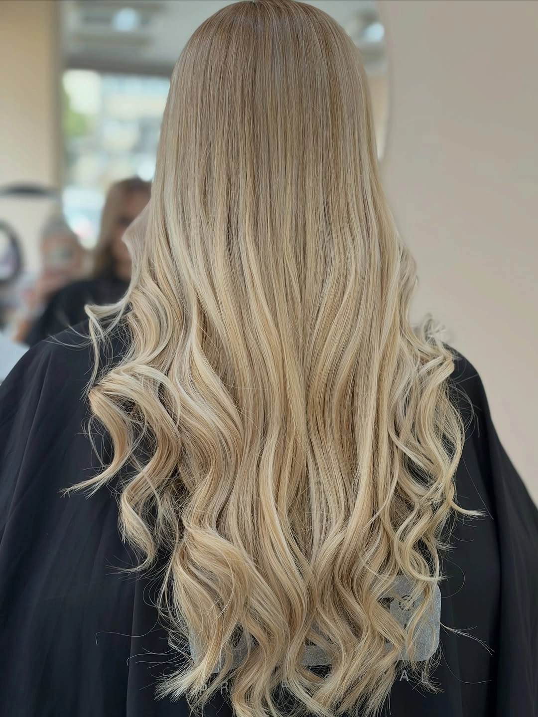 Back view of long cream blonde hair with curled lower ends