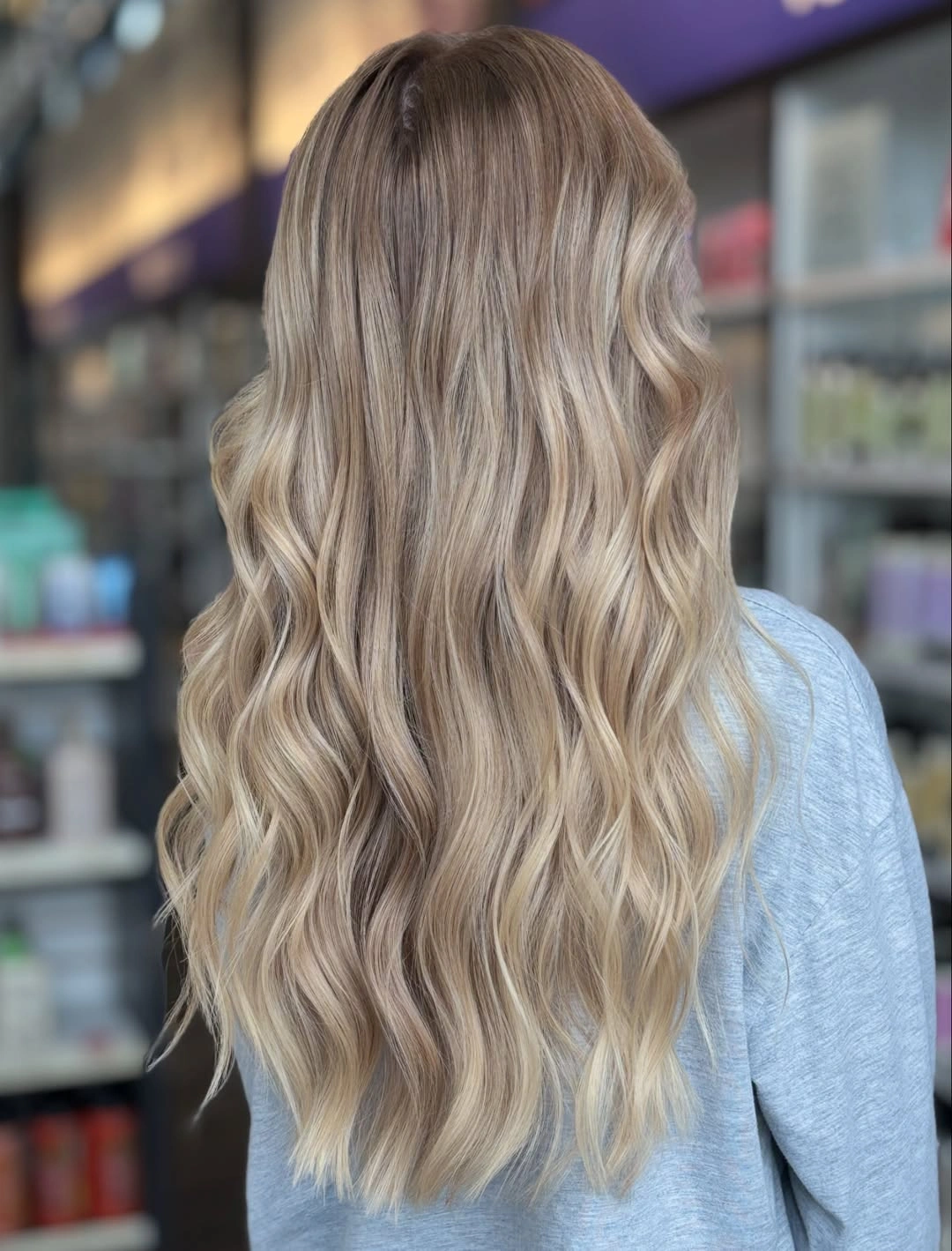 Back view of long wavy blonde hair with darker roots