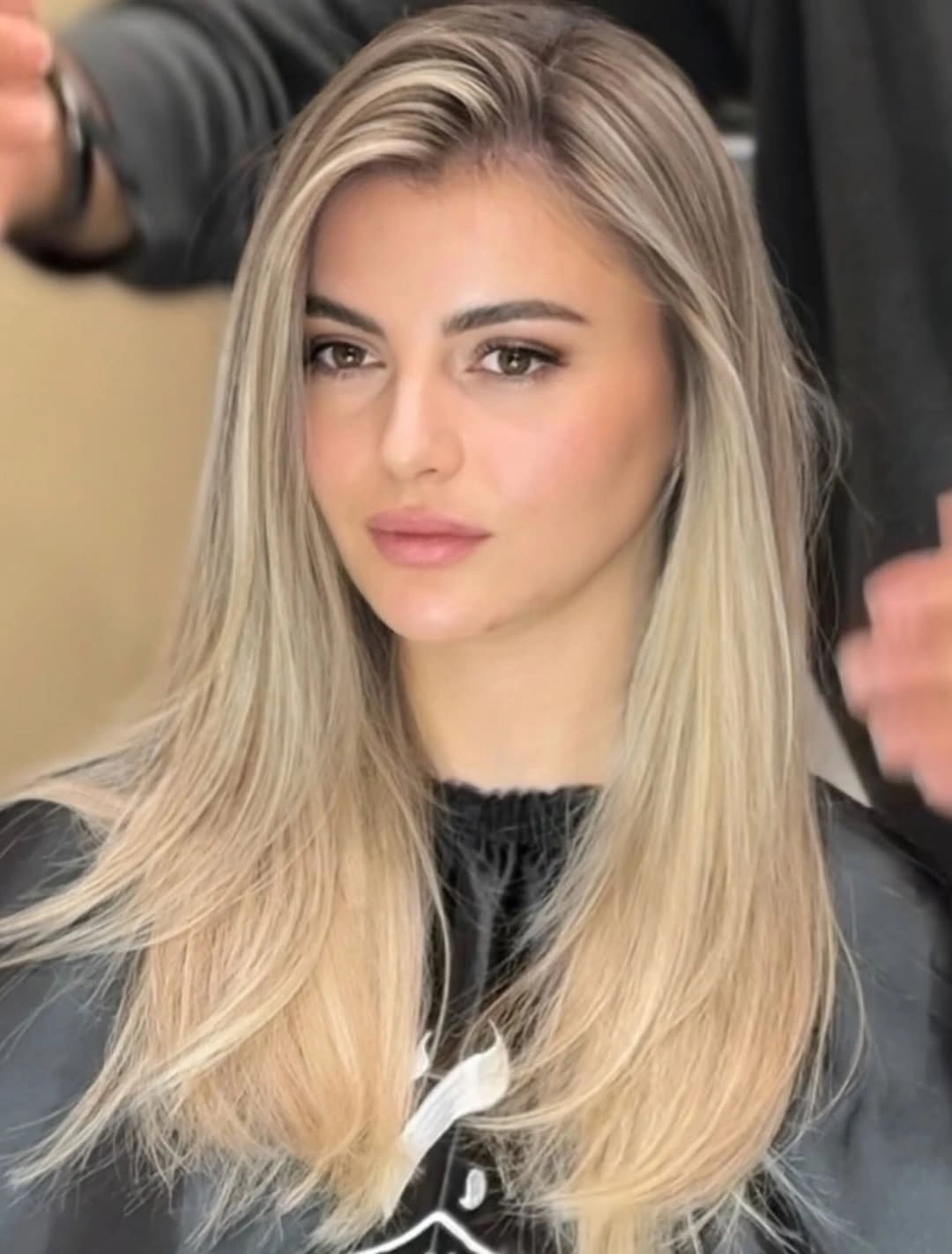 Long straight blonde hair with side part and darker ash roots