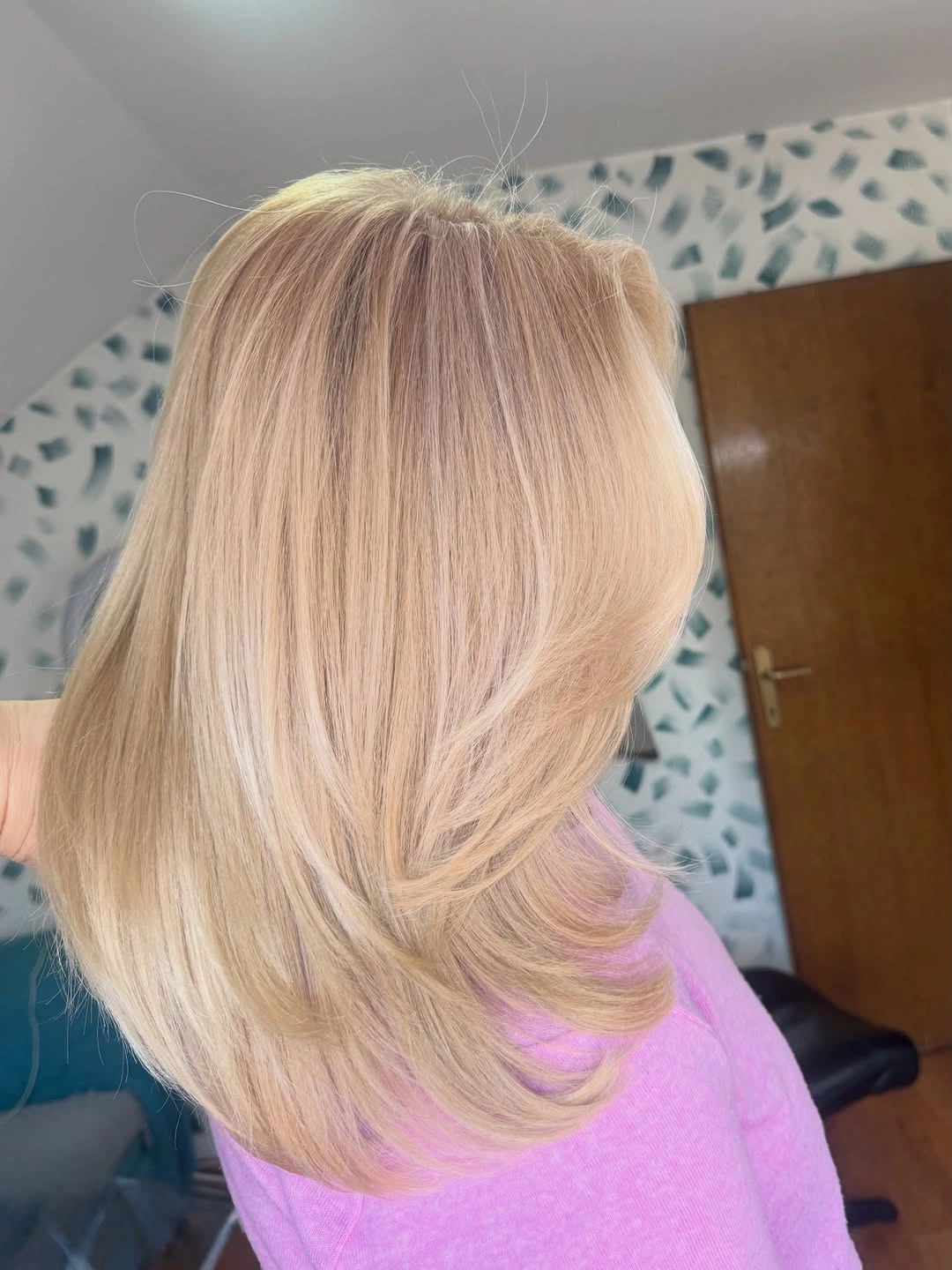 Medium-length peach-beige blonde hair with rounded flipped layers
