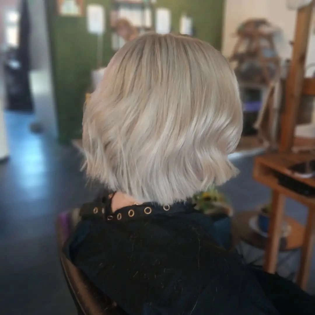Short wavy icy blonde bob with rounded nape-length shape