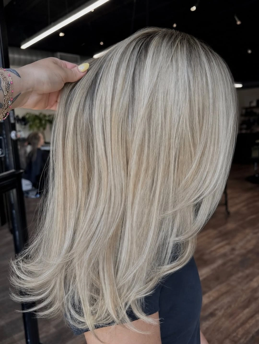 Medium-length layered pale blonde hair with flipped airy ends