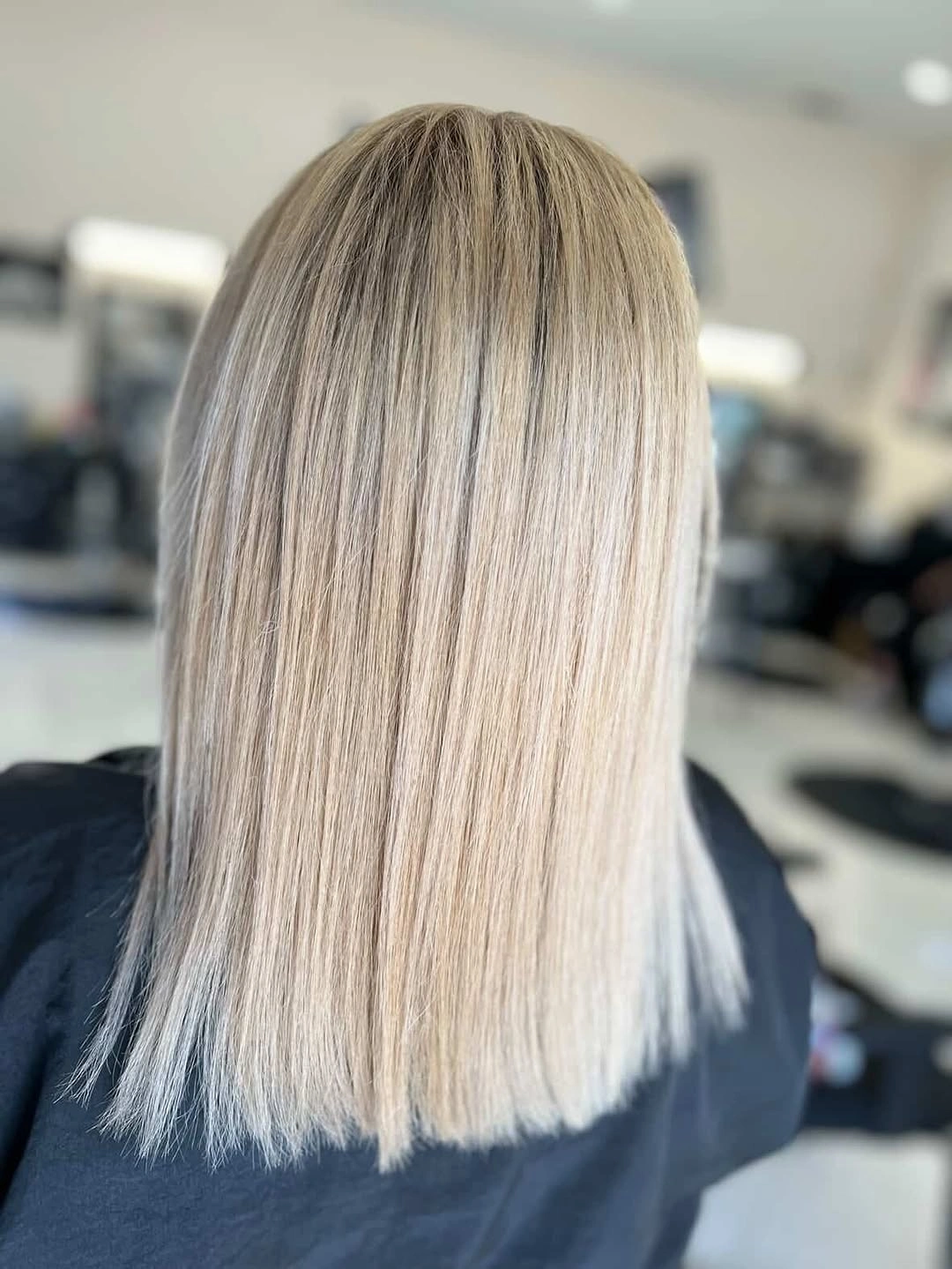 Straight beige blonde long bob with darker roots and blunt ends