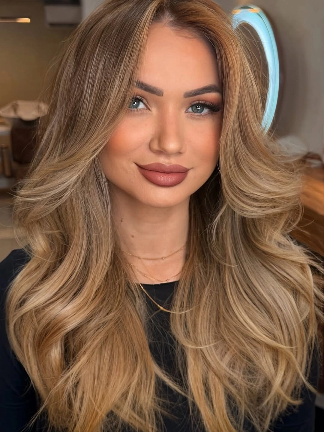 Long warm blonde layered hair with caramel ribbons and lifted front pieces