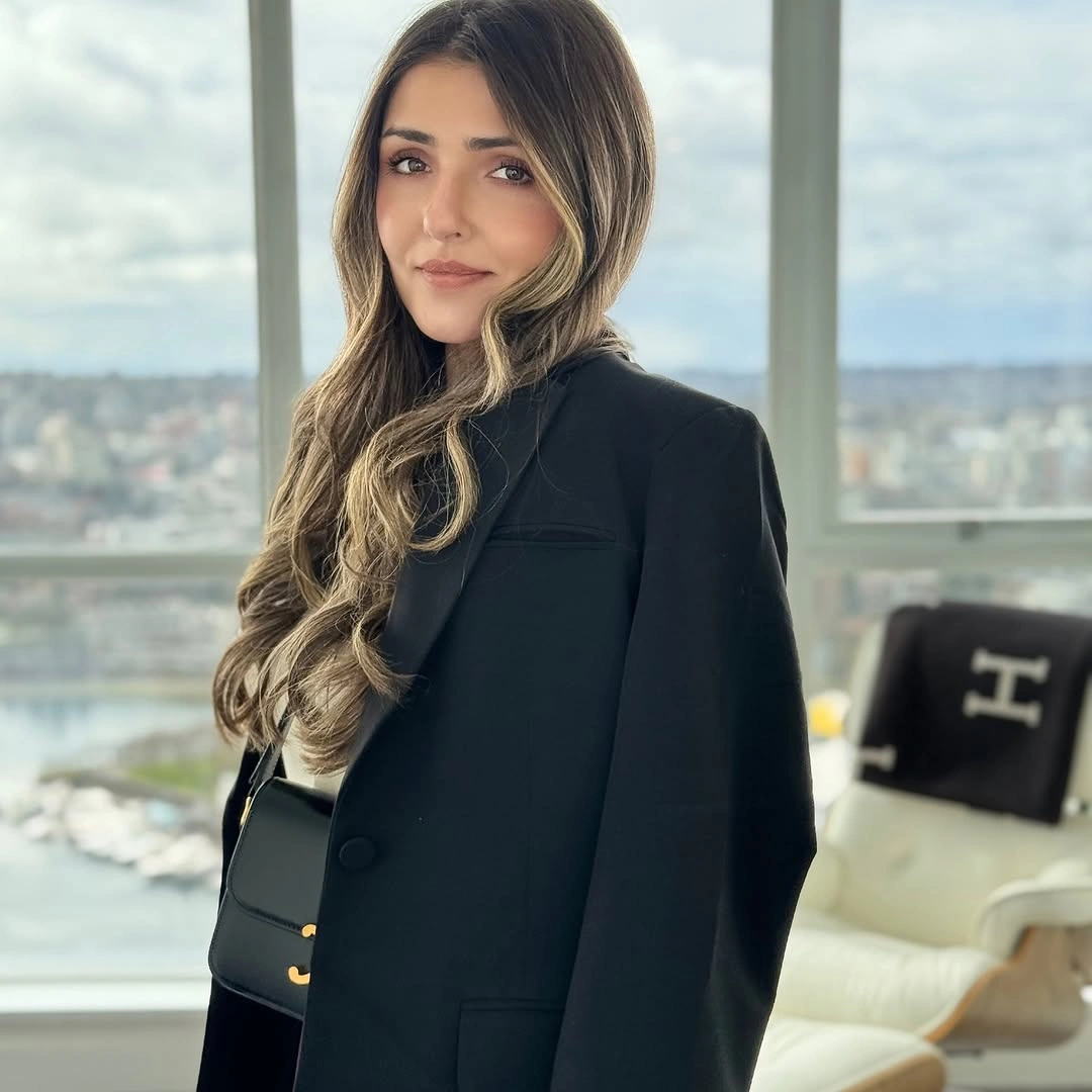 Black blazer dark top black shoulder bag by large window