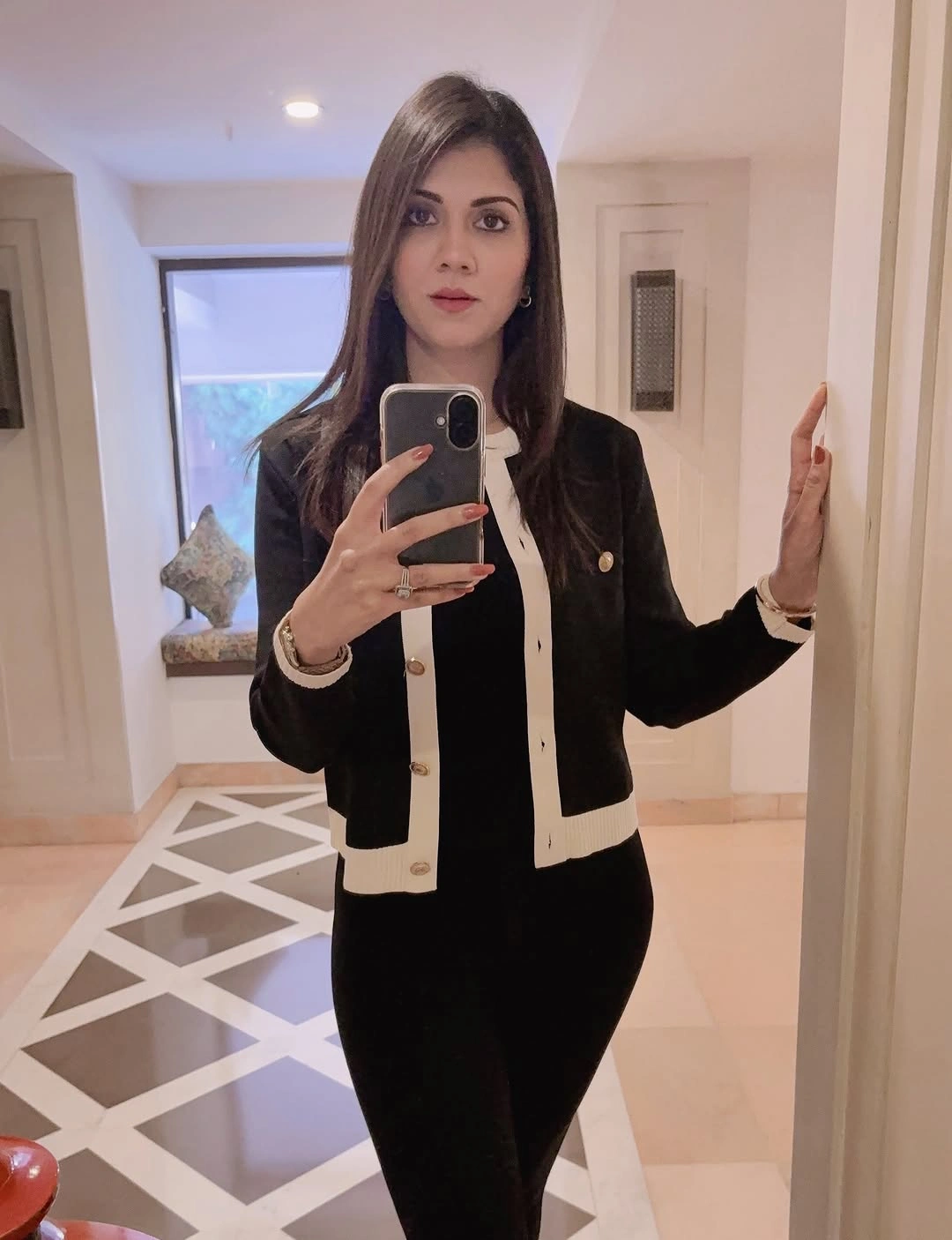 Black cardigan with white trim over light blouse and black bottom