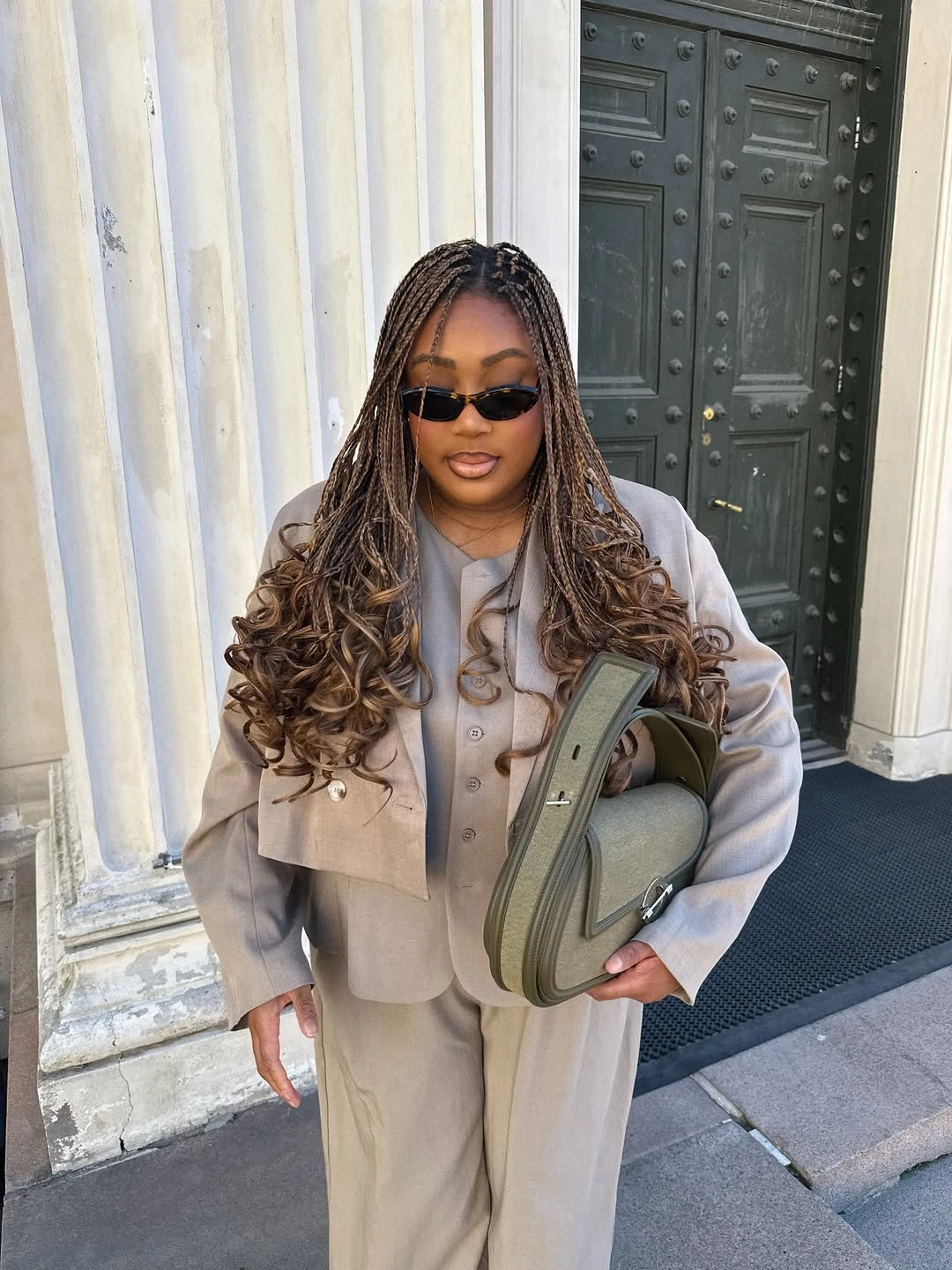 Taupe jacket trousers light top structured handbag and dark sunglasses